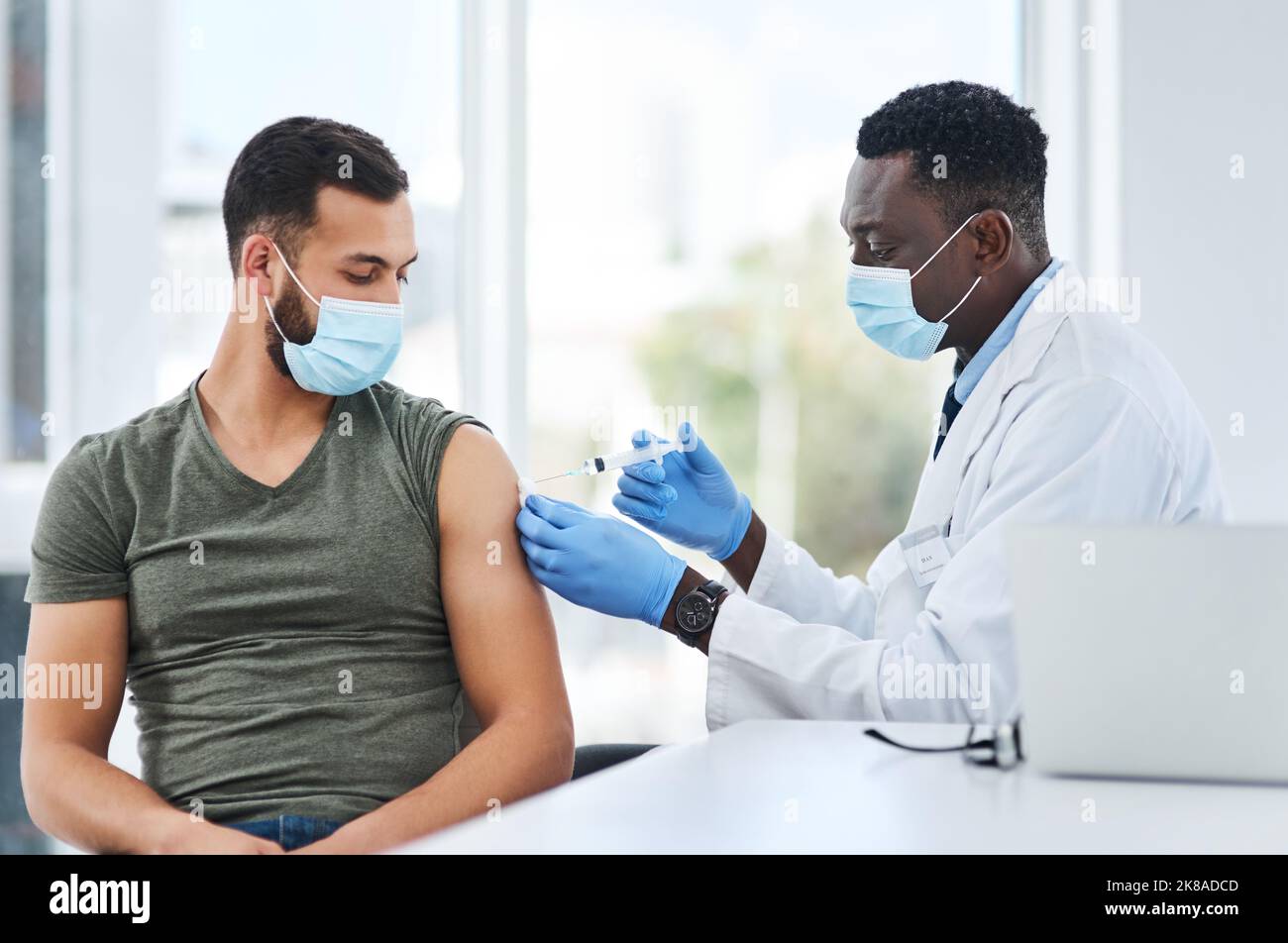 Non tutta l'armatura è di metallo. Un medico che inietta un paziente nel suo braccio durante una consultazione in una clinica. Foto Stock