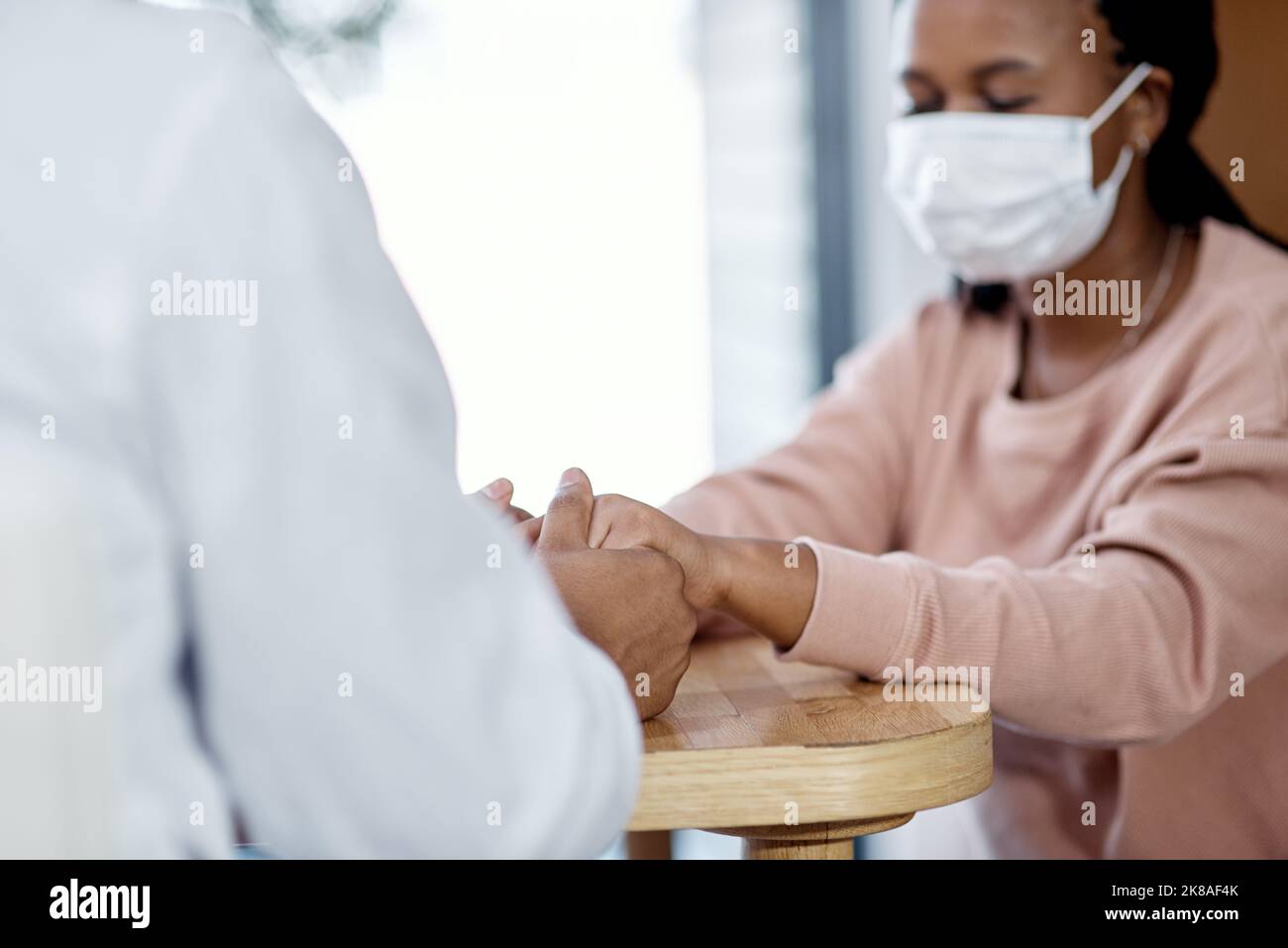 Non è solo un lavoro, è un impegno ad aiutare gli altri. Primo piano di un medico non riconoscibile che tiene le mani con un paziente durante una consultazione. Foto Stock
