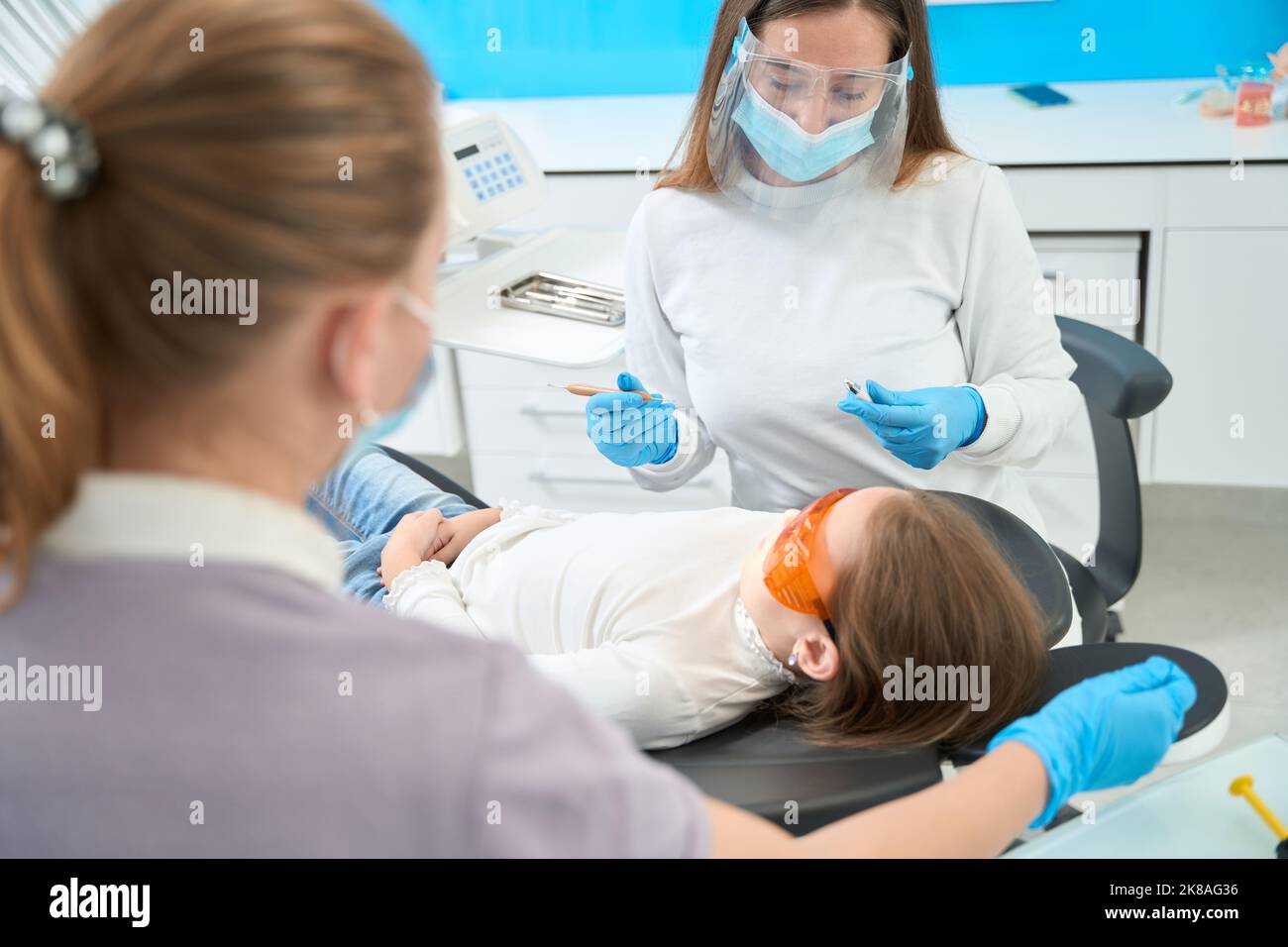 Dentista pediatrico in guanti di nitrile che si prepara ad esaminare il paziente Foto Stock