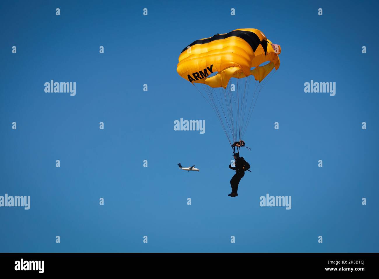 Un membro dell'esercito degli Stati Uniti Golden Knights paracadute in al Miramar Airshow 2022 mentre il suo aereo atterra nel backgroud a San Diego, California Foto Stock