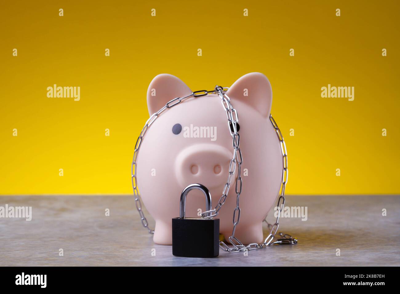 Chiudiosassata. Risparmio bloccato. La banca del piggy è legata con una catena e bloccata. Concetto di protezione dei soldi. Foto Stock