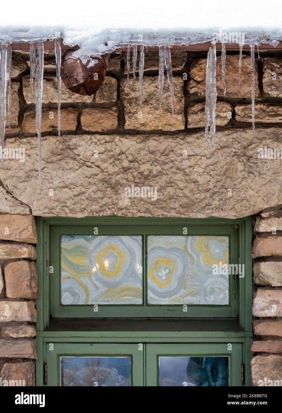 Le cicliche si agguantano sulle finestre decorative dell'edificio in pietra Foto Stock