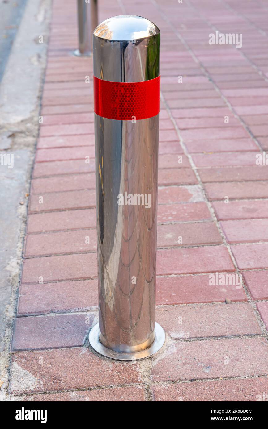 Pali di parcheggio in acciaio inossidabile che separano il marciapiede dalla strada. Prevenzione. Illegale. Controllo. Urbano. Città. Parcheggio non disponibile. Sentiero Foto Stock