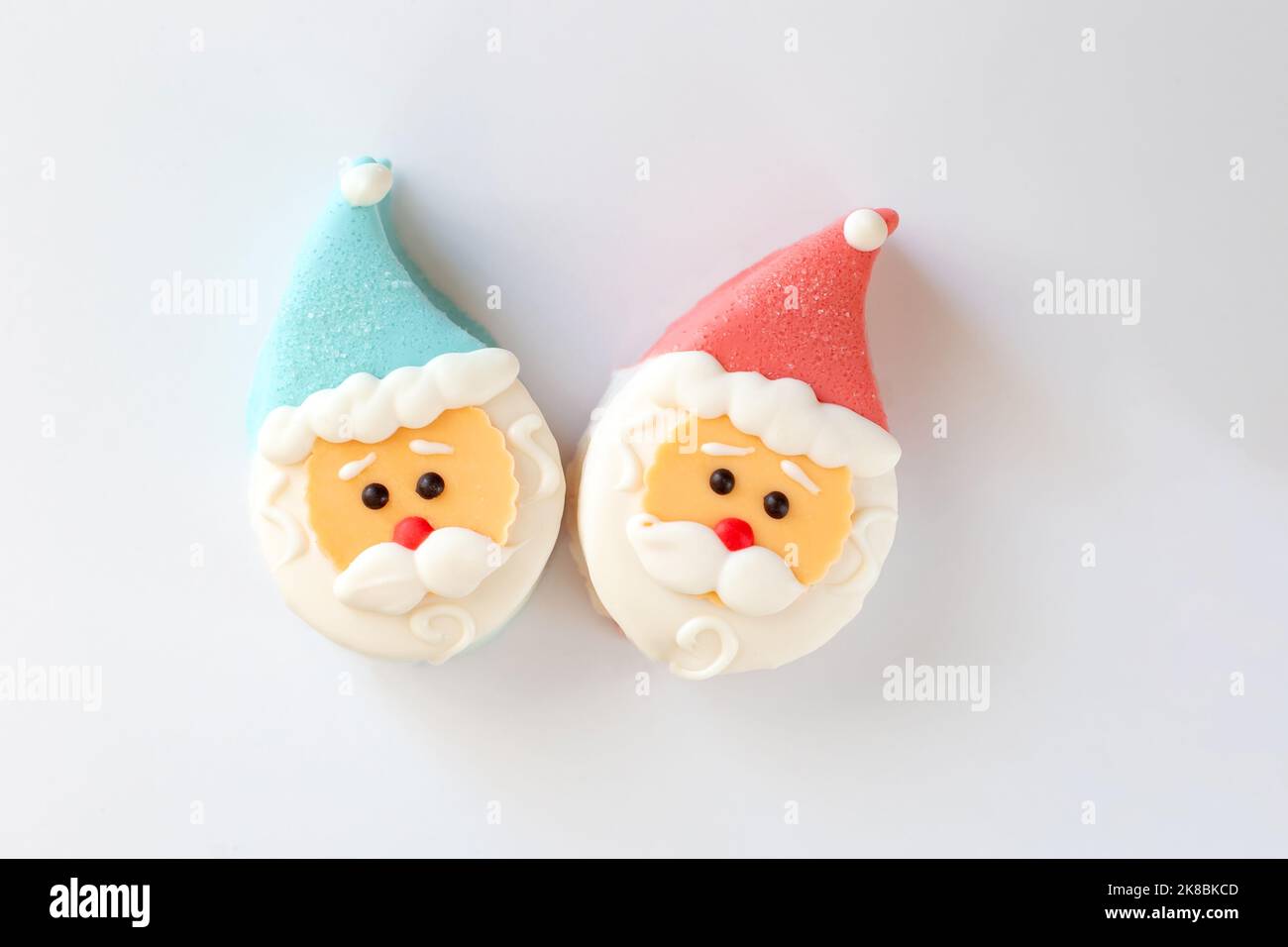 Due deliziosi dessert a forma di testa di Babbo Natale, con un cappuccio rosso e blu Foto Stock