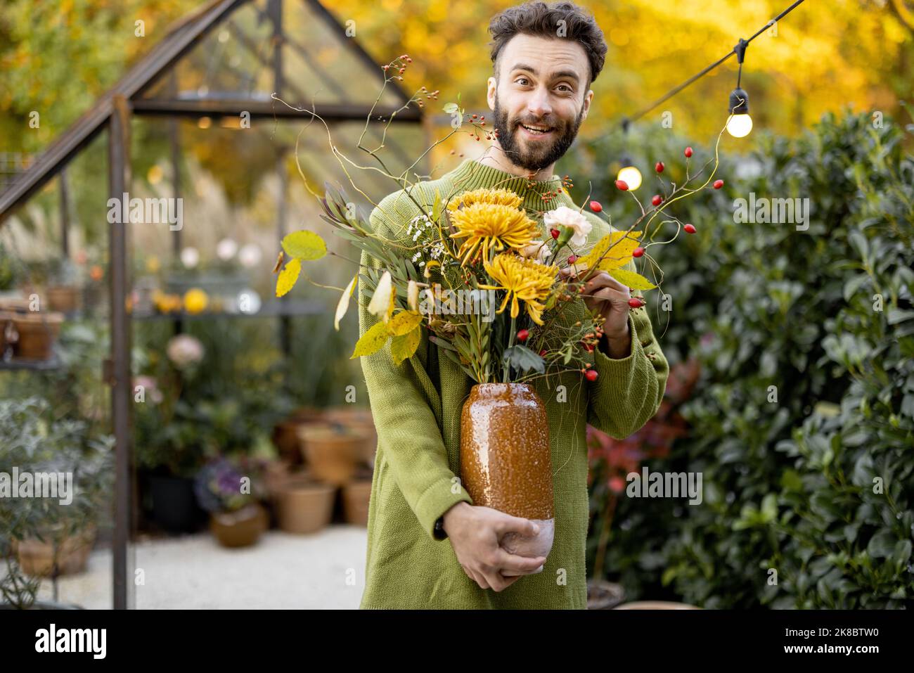 Uomo con bouquet in giardino Foto Stock