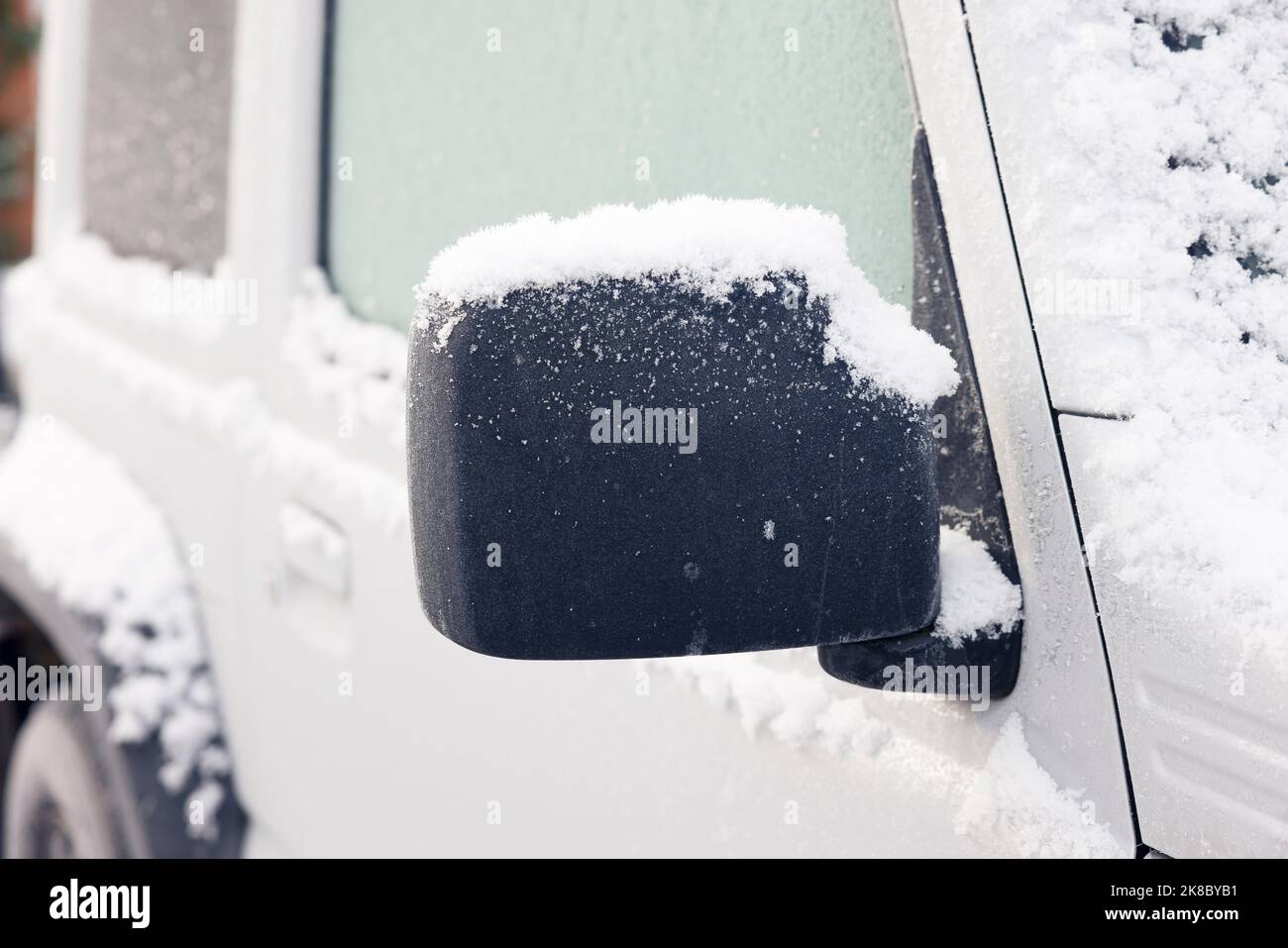 Primo piano della porta dell'auto e dello specchietto retrovisore esterno coperto di neve in inverno, Regno Unito Foto Stock