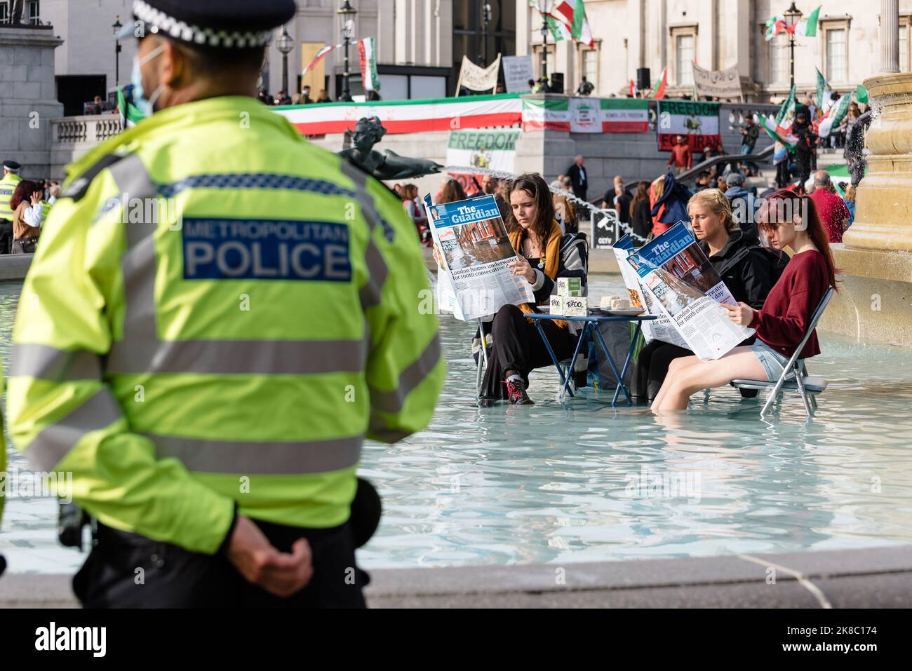 Londra, Regno Unito. 22 ottobre 2022. Attivisti per i diritti degli animali Animal Rebellion tinge Trafalgar Square fontana verde mentre si trova ad un tavolo in esso e leggere un giornale. La protesta fa seguito ai commenti dell'ex segretario di casa Suella Braverman, che ha citato gli attivisti come "Guardian-Reading, tofu-eating, wokerati”. Gli attivisti chiedono una transazione per un sistema alimentare basato sulle piante e per il governo di selvaggio della terra. Credit: Andrea Domeniconi/Alamy Live News Foto Stock