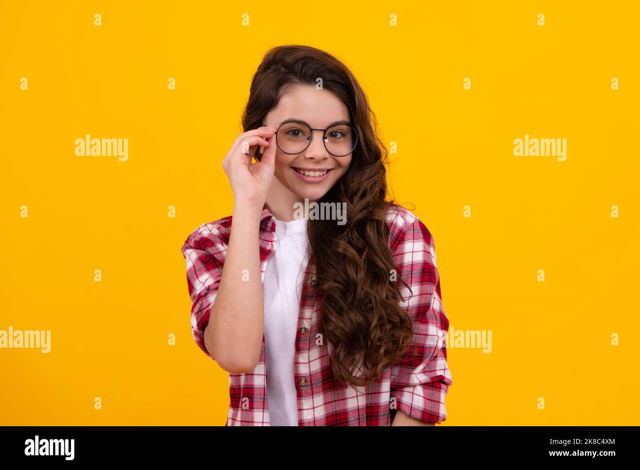 Ragazza cute scuola che indossa gli occhiali su sfondo giallo studio, intelligente studentessa intelligente in occhiali. Studente nerd, scolarista genio, Scuola Foto Stock