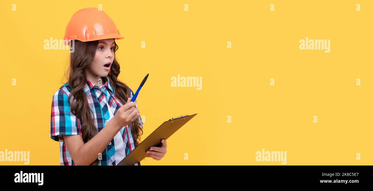 sicurezza di lavoro competenza. ragazza stupita in elmetto protettivo prendere appunti. Allestitore per bambini con poster orizzontale del casco. Intestazione banner, spazio di copia. Foto Stock