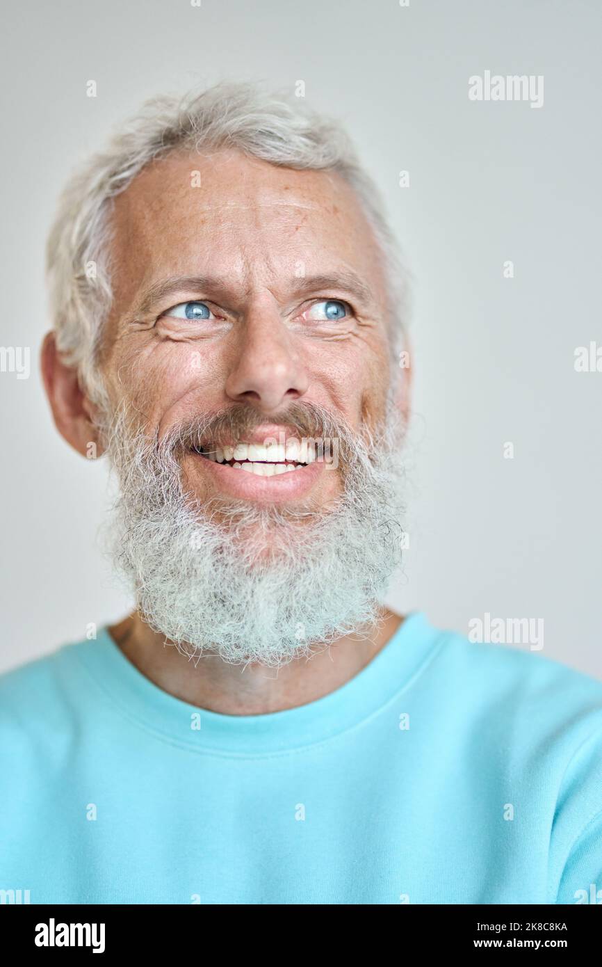 Un anziano sorridente che guarda lontano sognando isolato su bianco. Primo piano verticale Foto Stock