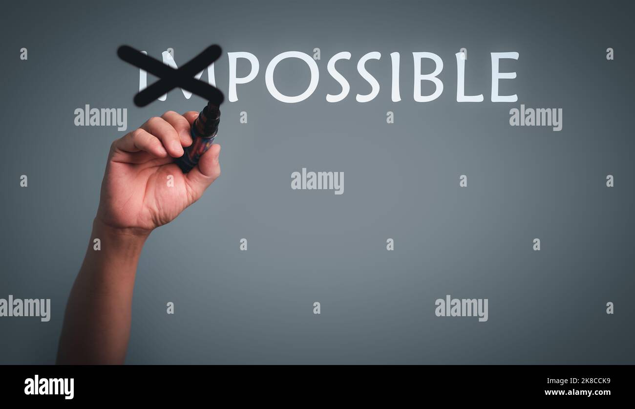 Mano con penna cambiare la parola impossibile a possibile con testo im cross out. Foto Stock