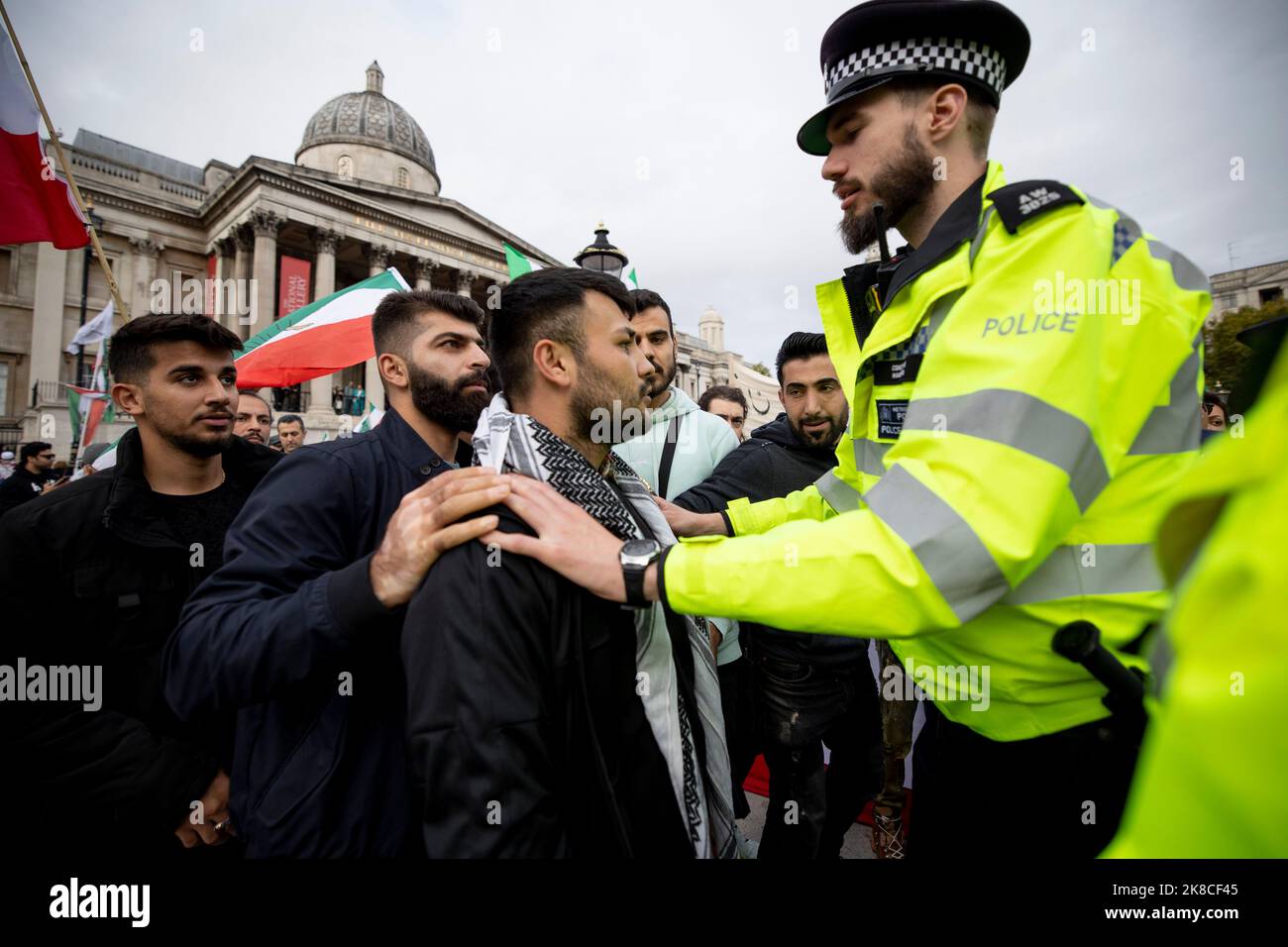 Londra, Regno Unito. 22nd Ott 2022. Un ufficiale di polizia incontrato ha visto stare in piedi tra un conflitto tra gli iraniani e iracheni-curdi al di fuori della National Portrait Gallery. Gli iraniani e i curdi iracheni residenti nel Regno Unito e i loro sostenitori continuano a protestare per le strade e chiedono al governo britannico di smettere di sostenere la brutalità del governo islamico iraniano dopo che Mahsa Amini è morto in custodia dopo essere stato arrestato dalla polizia morale iraniana per non aver indossato il suo velo il modo corretto. (Foto di Hesther ng/SOPA Images/Sipa USA) Credit: Sipa USA/Alamy Live News Foto Stock