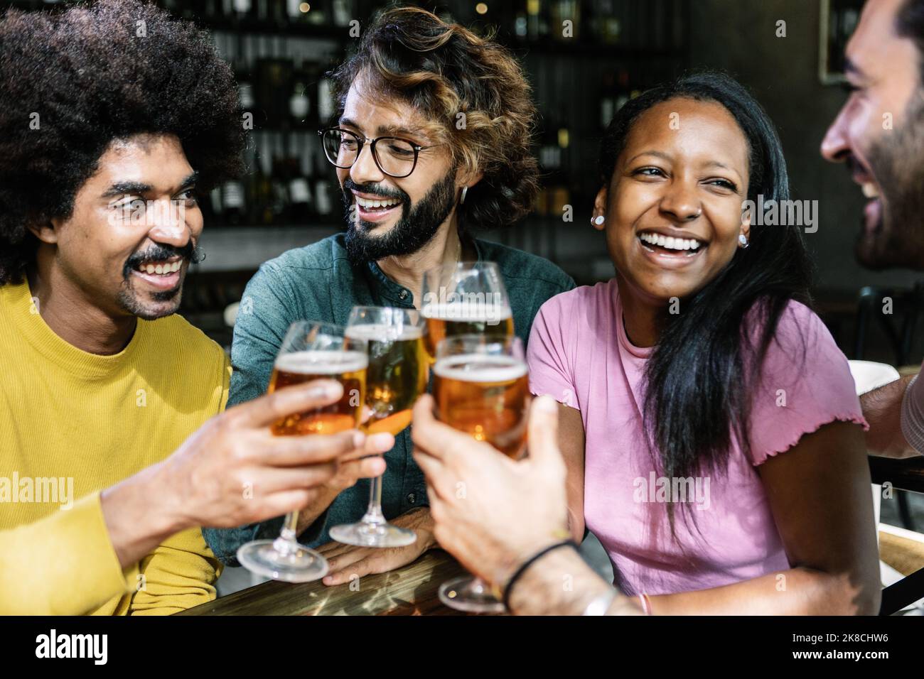 Felici giovani amici multirazziali che si divertono insieme a bere birra al bar della birreria Foto Stock