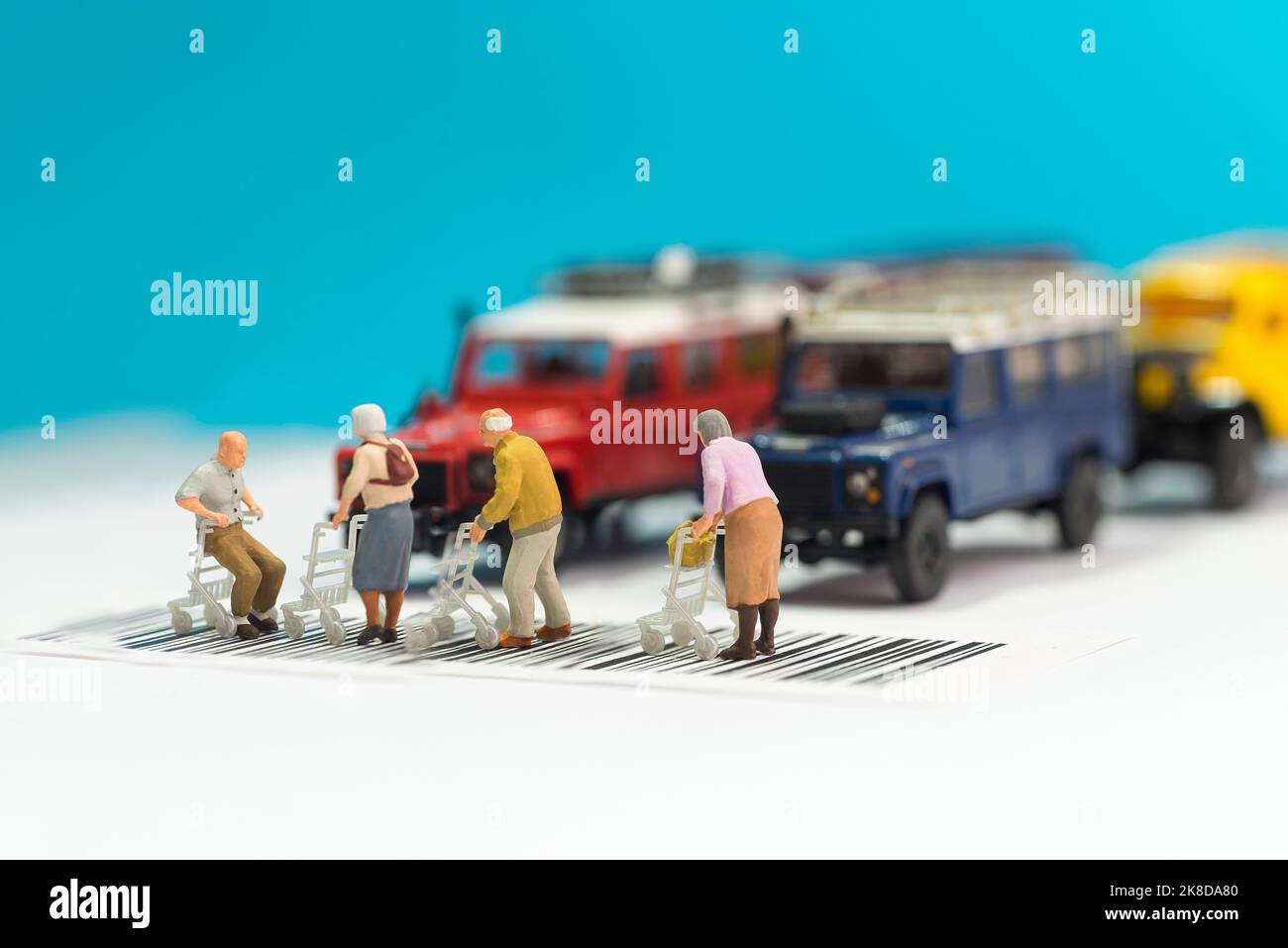 Giocattoli in miniatura un gruppo di persone anziane con sedia a rotelle che attraversa una strada - concetto di sicurezza stradale per gli anziani. Foto Stock