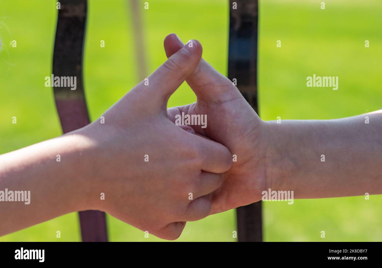 Due bambini che giocano una battaglia con il pollice, con l'obiettivo di bloccare il pollice del giocatore avversario Foto Stock