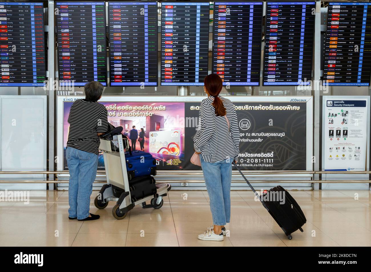 Bangkok, Thailandia - 26 ottobre 2022 : passeggero asiatico donna con bagagli guardare orario di partenza imbarco per controllare il volo all'aeroporto suvarnabhumi Foto Stock