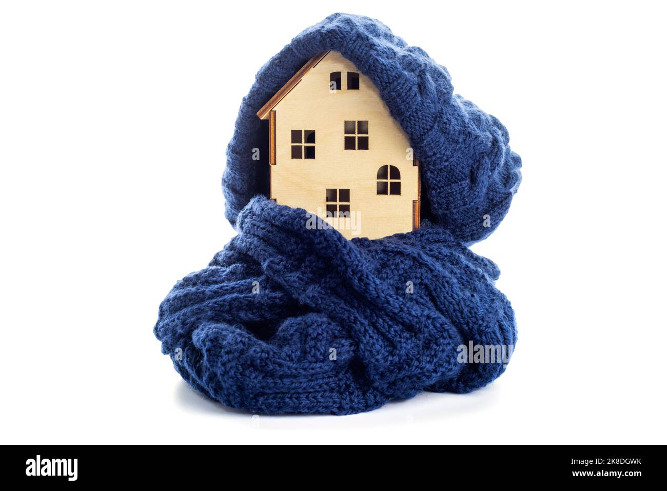 Casa giocattolo in legno con cappello caldo e sciarpa isolata su sfondo bianco Foto Stock