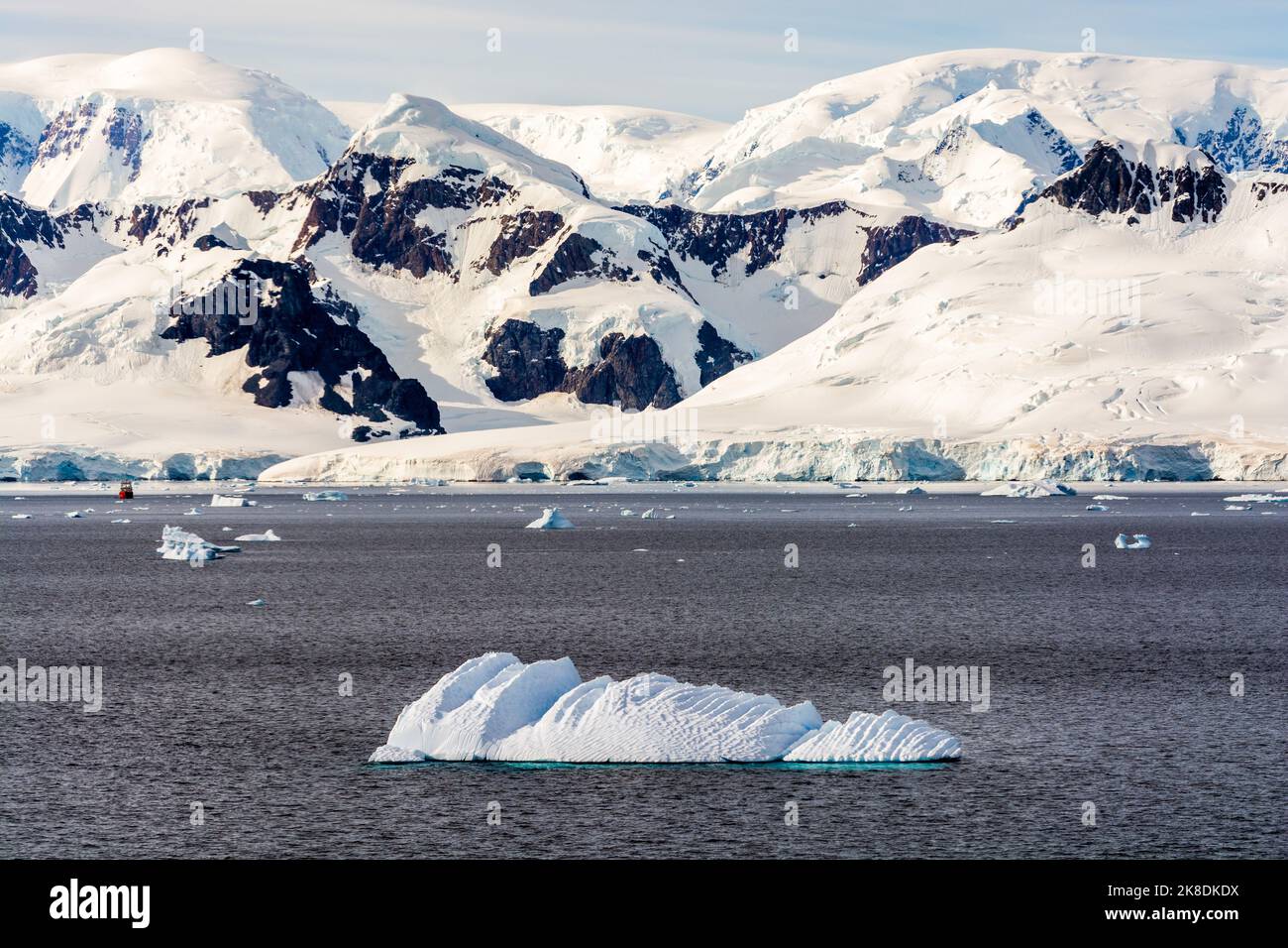 iceberg nello stretto di gerlache con l'isola di bryde e la penisola antartica sullo sfondo. nave della prefettura argentina al centro a sinistra. antartide Foto Stock
