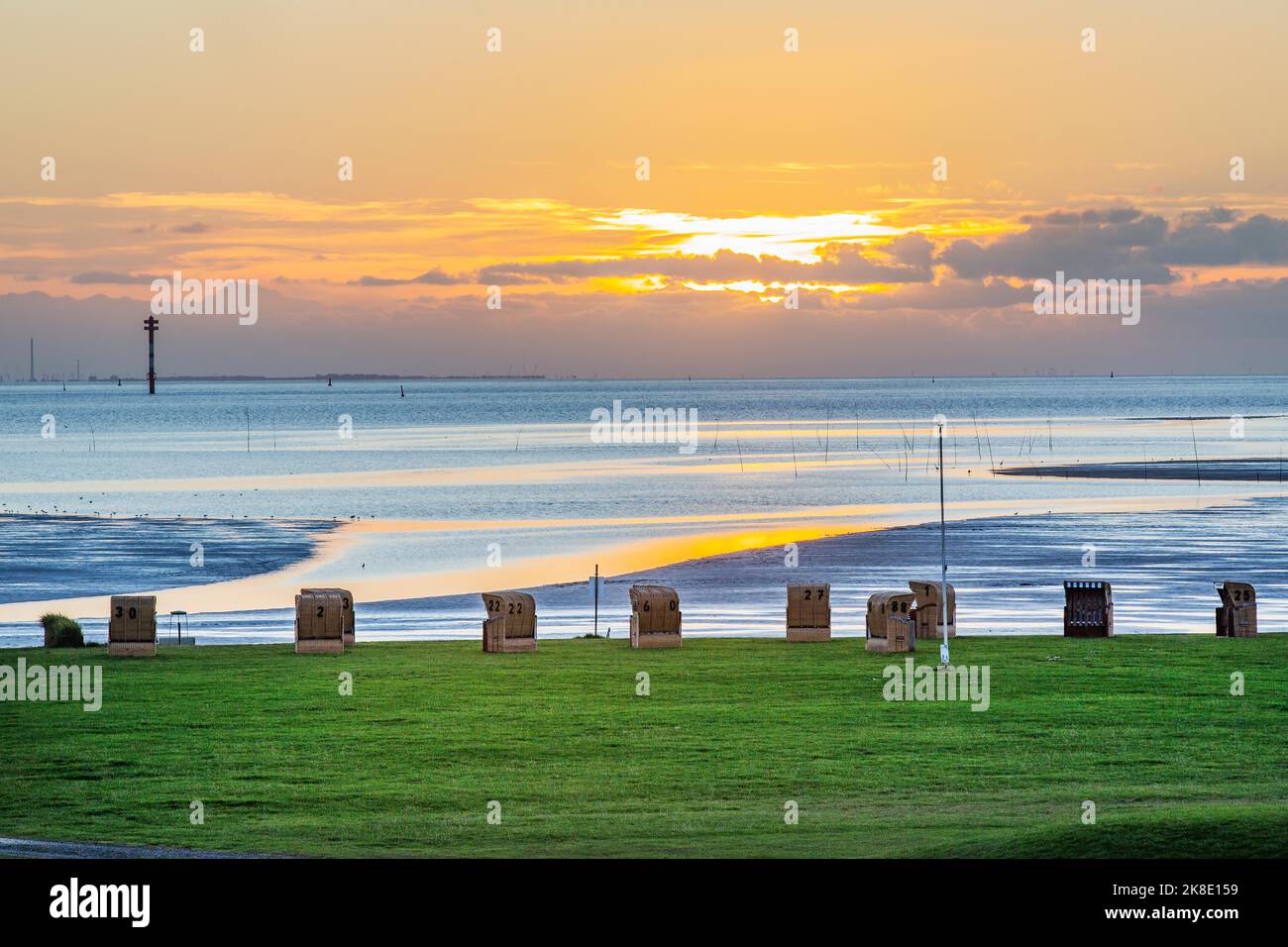 Spiaggia erbosa con sedie a sdraio al tramonto sul Mare di Wadden alla foce del Weser, Wremen, Wurster North Sea Coast, North Sea Coast, Land Wursten Foto Stock