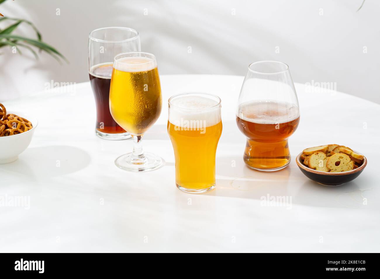 Diversi bicchieri di birra chiara scuro artigianale su superficie chiara copia spazio Foto Stock
