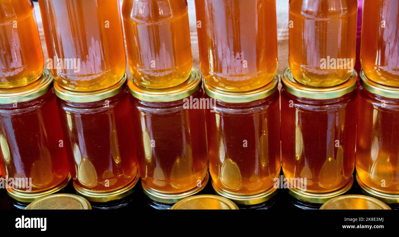 Il vasetto di vetro della piena di miele fresco con coperchio Foto Stock