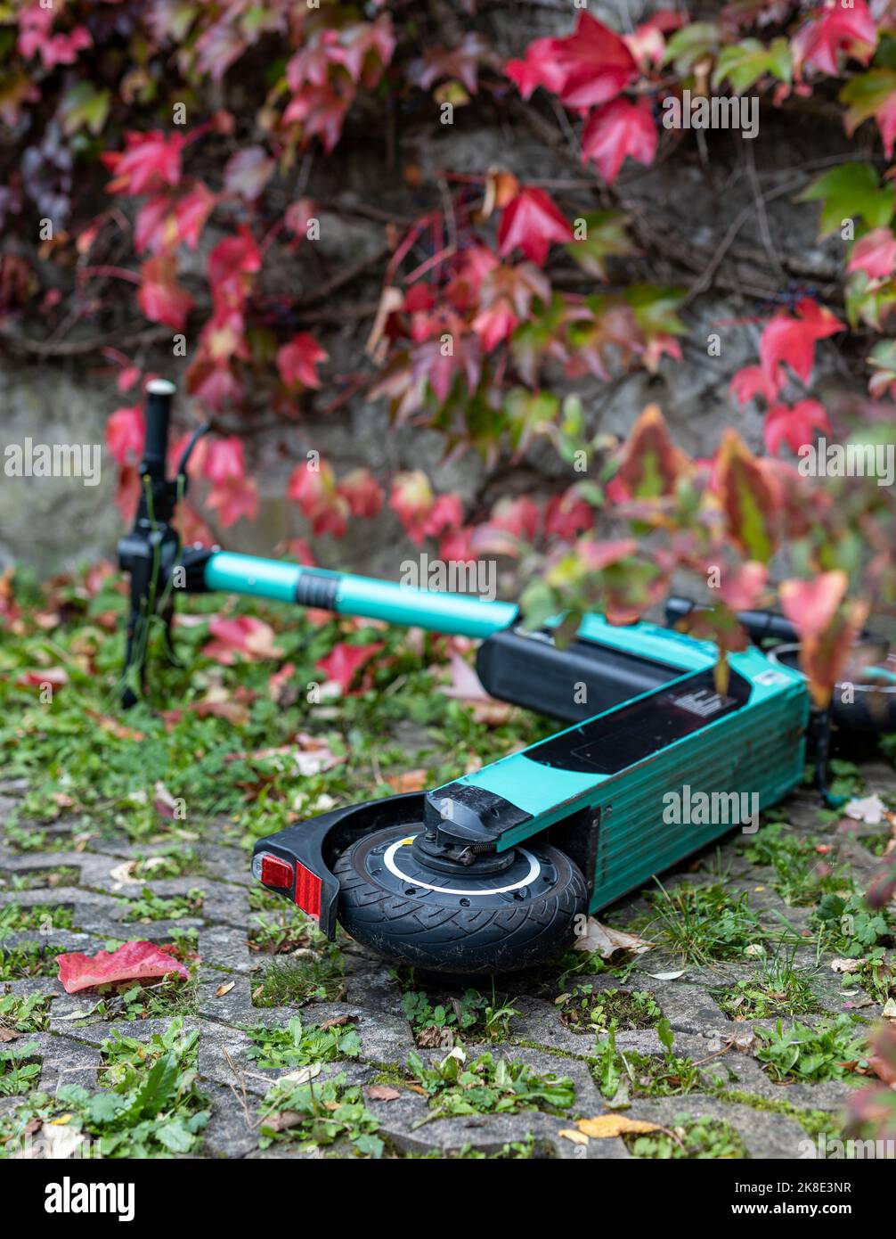 Uno scooter abbandonato vicino a caduta foglie autunnali. Foto Stock