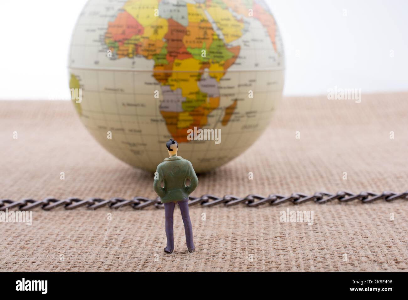 Figurina l uomo e il mondo con una catena in medio Foto Stock