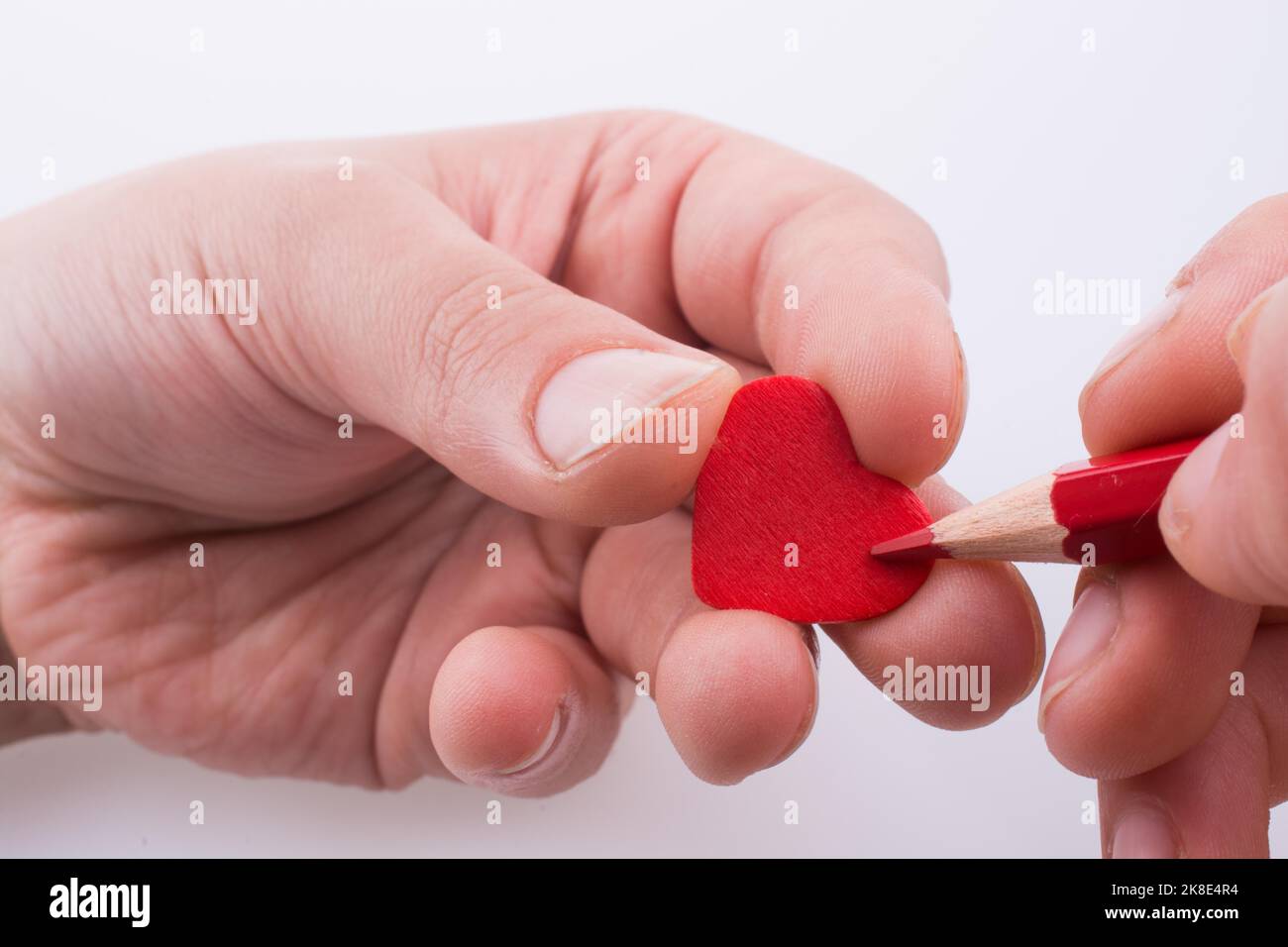 Puntamento a matita un cuore rosso Foto Stock