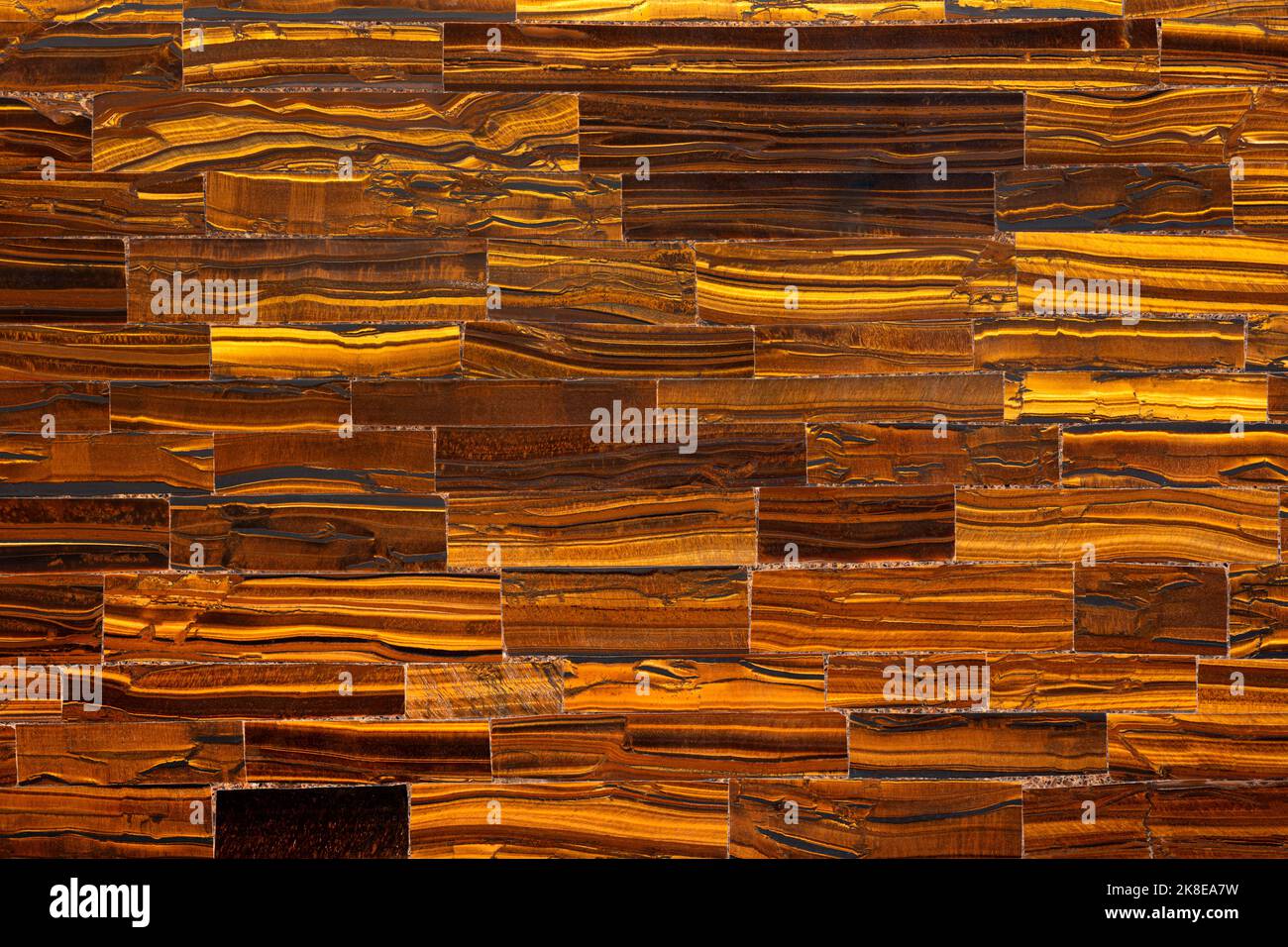 Tiger Eye Golden. Texture semipreziose come sfondo. Quarzo minerale bel colore marrone-dorato con lucentezza setosa. Struttura del materiale per un'esperienza unica Foto Stock