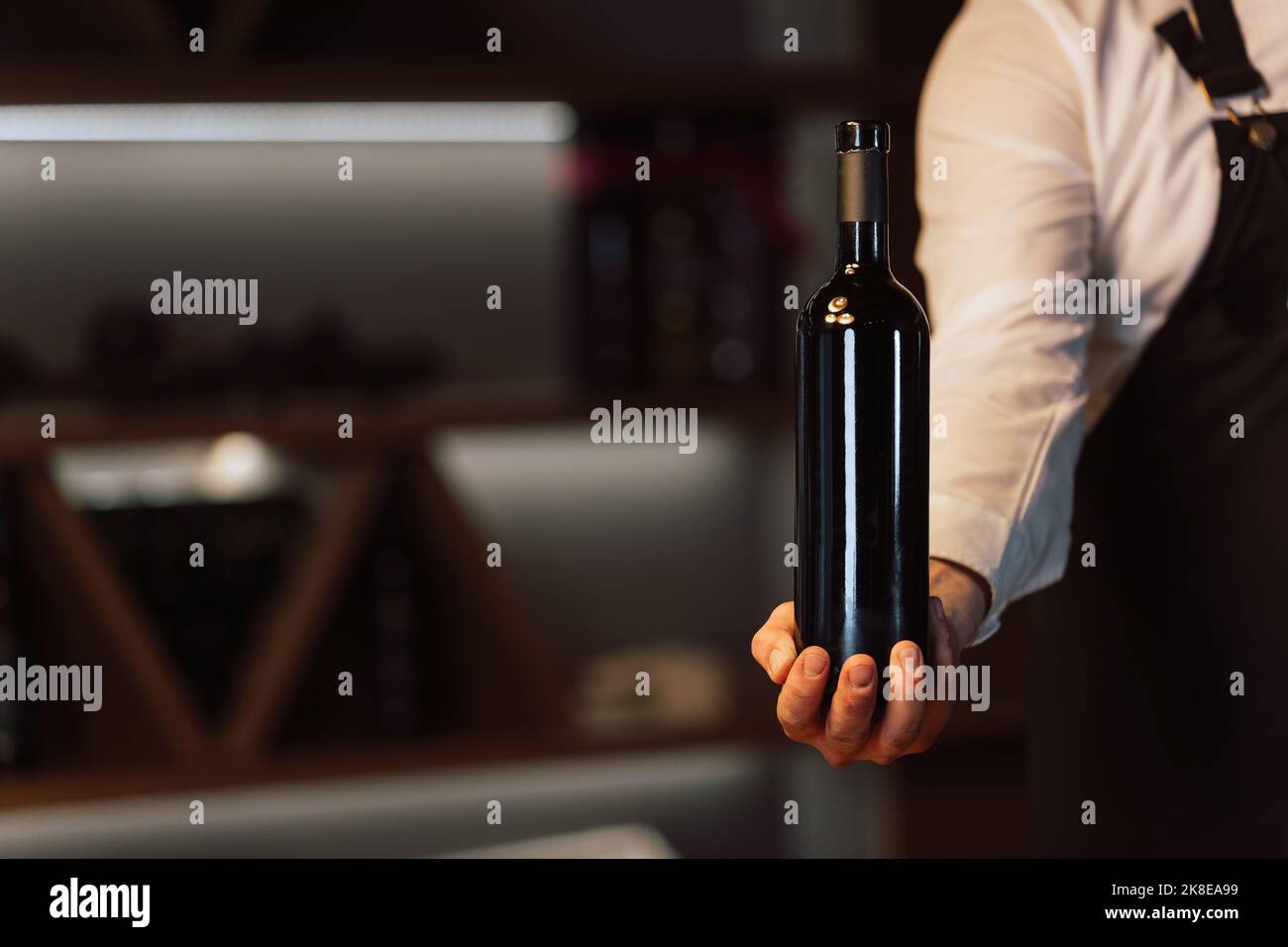 Cameriere che tiene in mano una bottiglia di vino Foto Stock