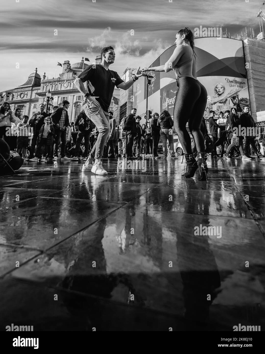 Una coppia danza bachata in un Wet Piccadilly Circus a Londra. Foto Stock