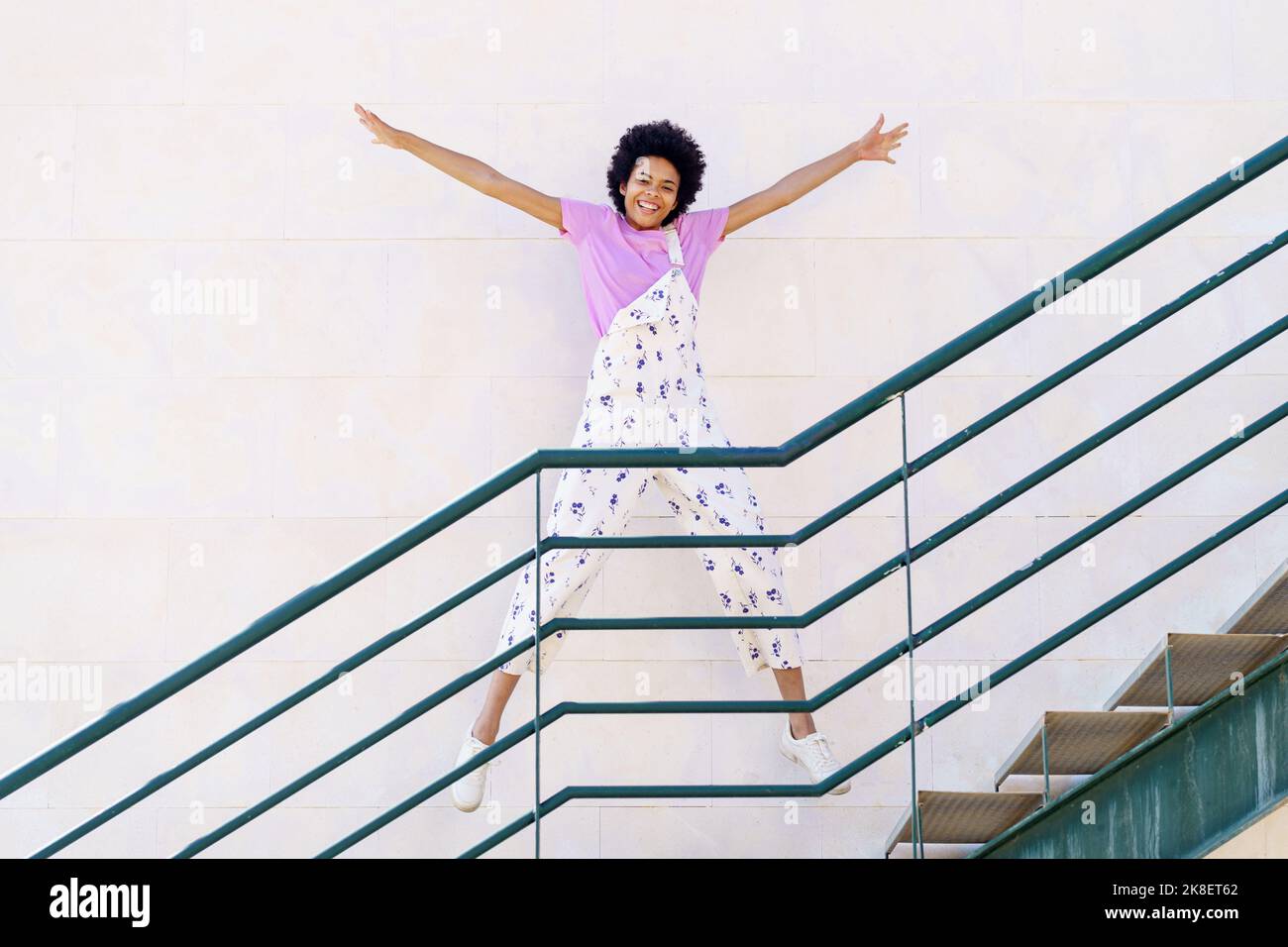 Allegra donna nera che salta sulla scala Foto Stock