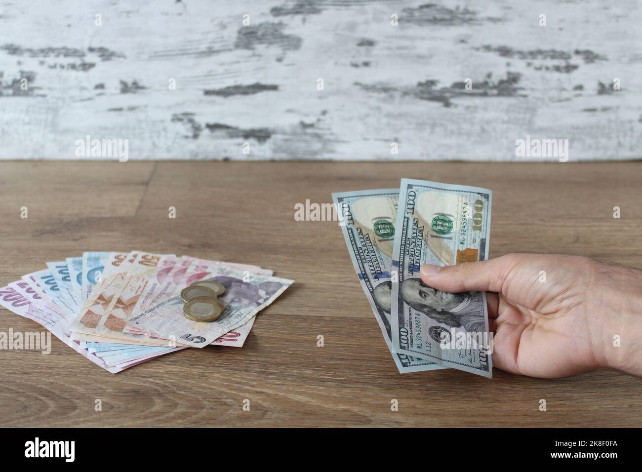 Cambia denaro, uomo in possesso di dollari e lire turche con le mani. Idea di concetto di scambio. Foto Stock