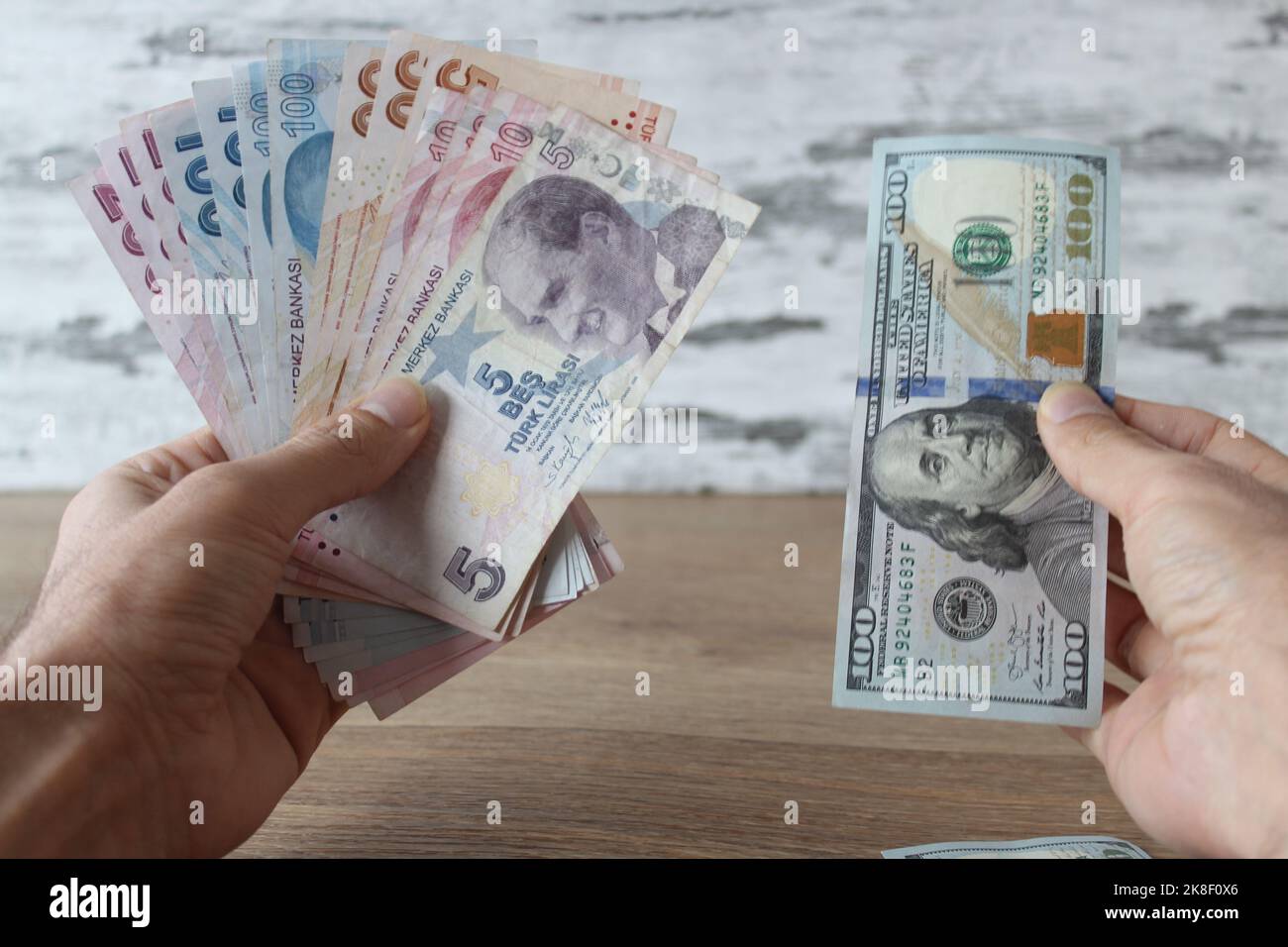 Cambia denaro, uomo in possesso di dollari e lire turche con le mani. Foto Stock