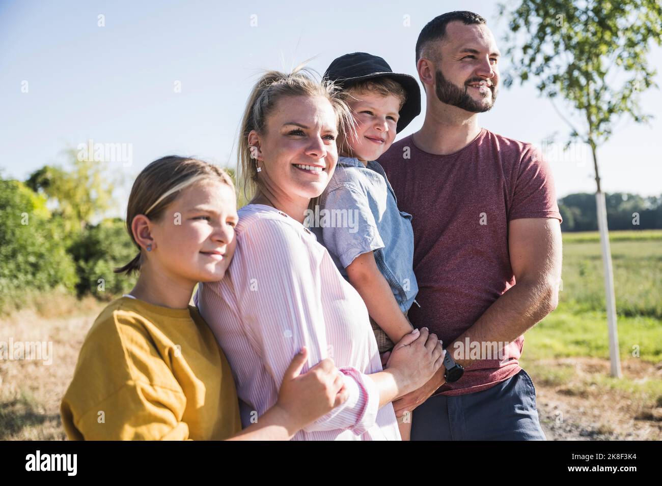 Famiglia fiduciosa in piedi in natura guardando a distanza Foto Stock