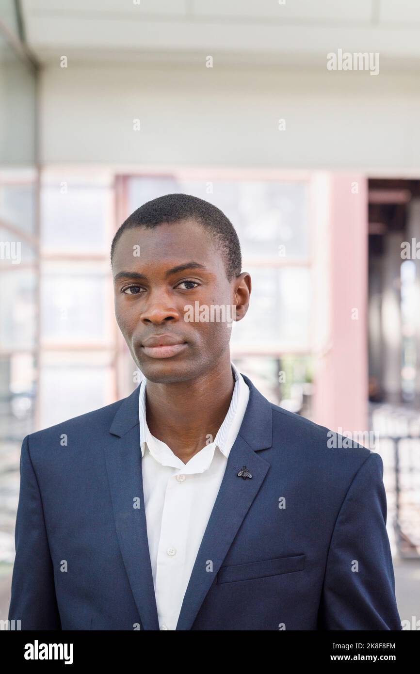 Giovane uomo d'affari in piedi alla stazione ferroviaria Foto Stock