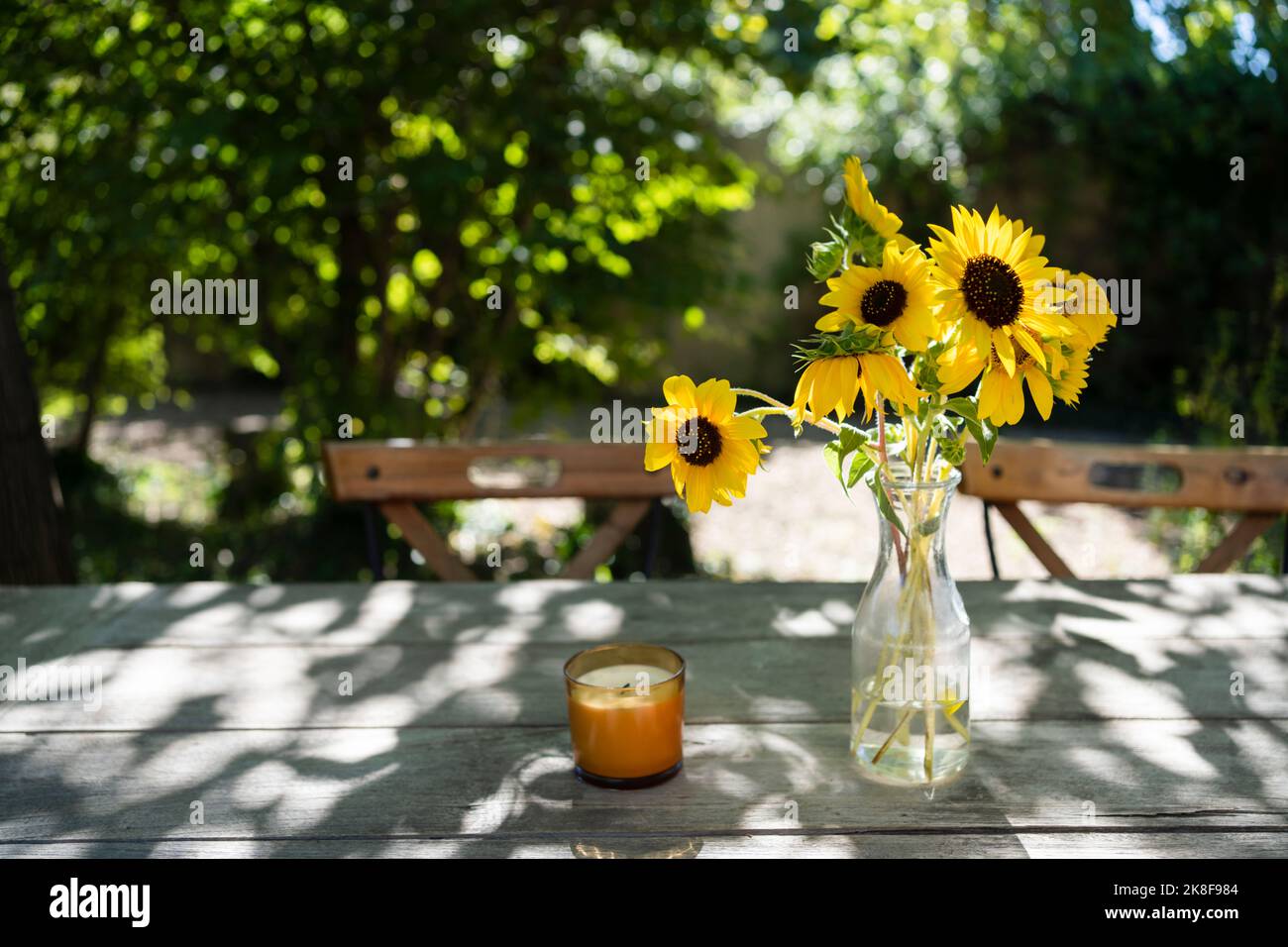 Candela e vaso di fiori sul tavolo Foto Stock