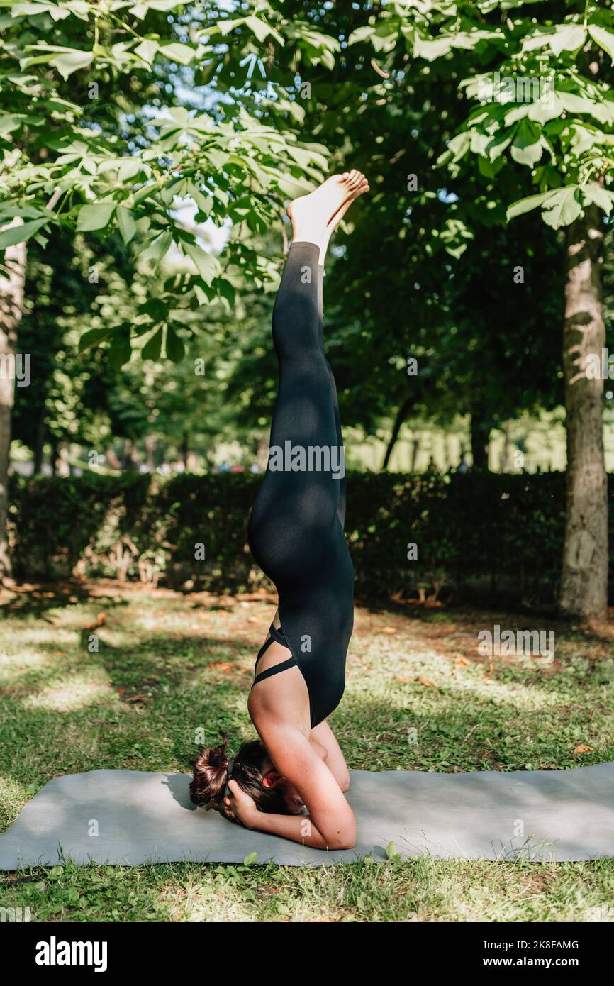 Insegnante di yoga che pratica la posizione di Salamba Shirshasana nel parco Foto Stock