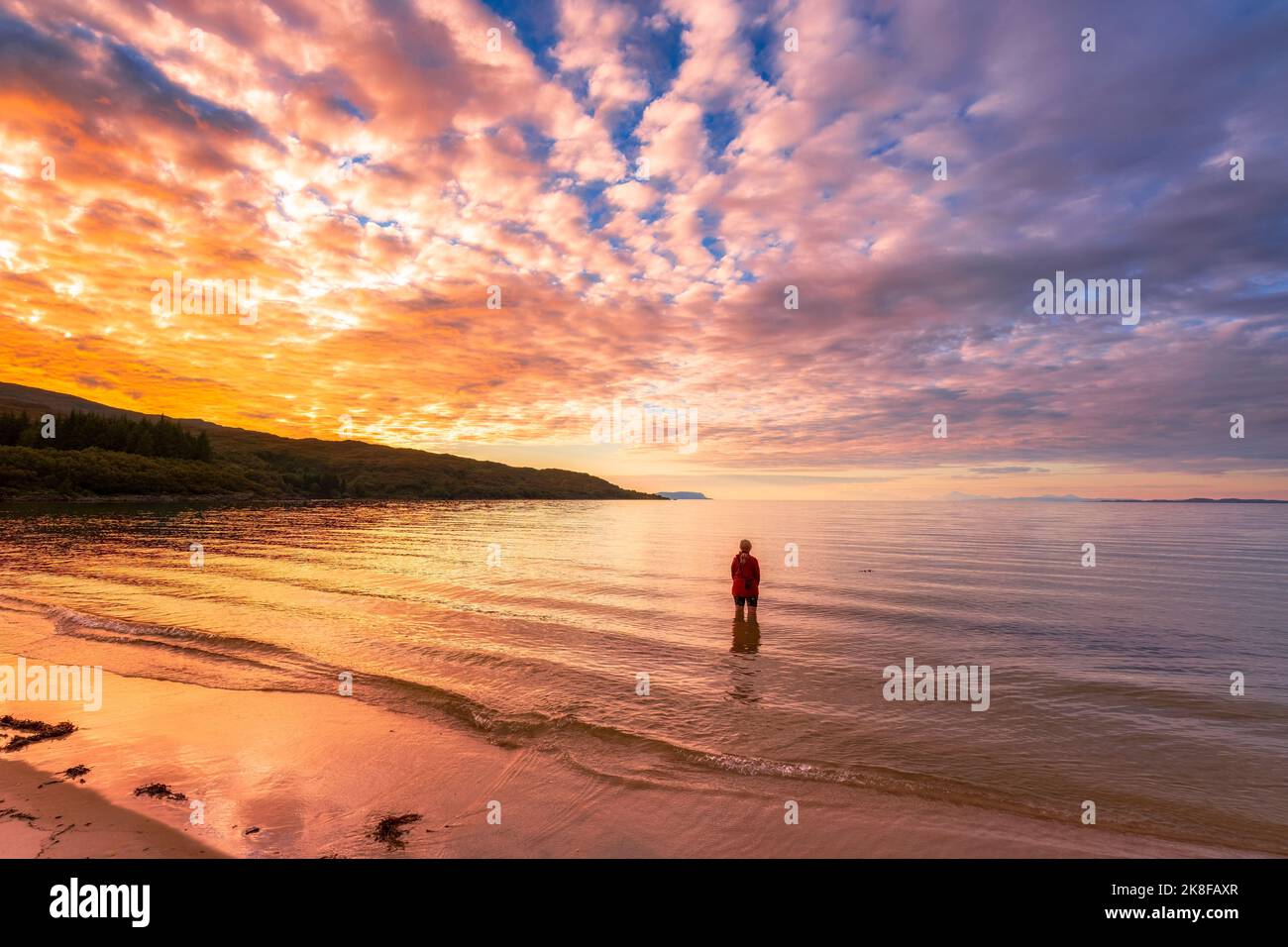 Donna in piedi in acqua alla spiaggia di Singing Sands Foto Stock