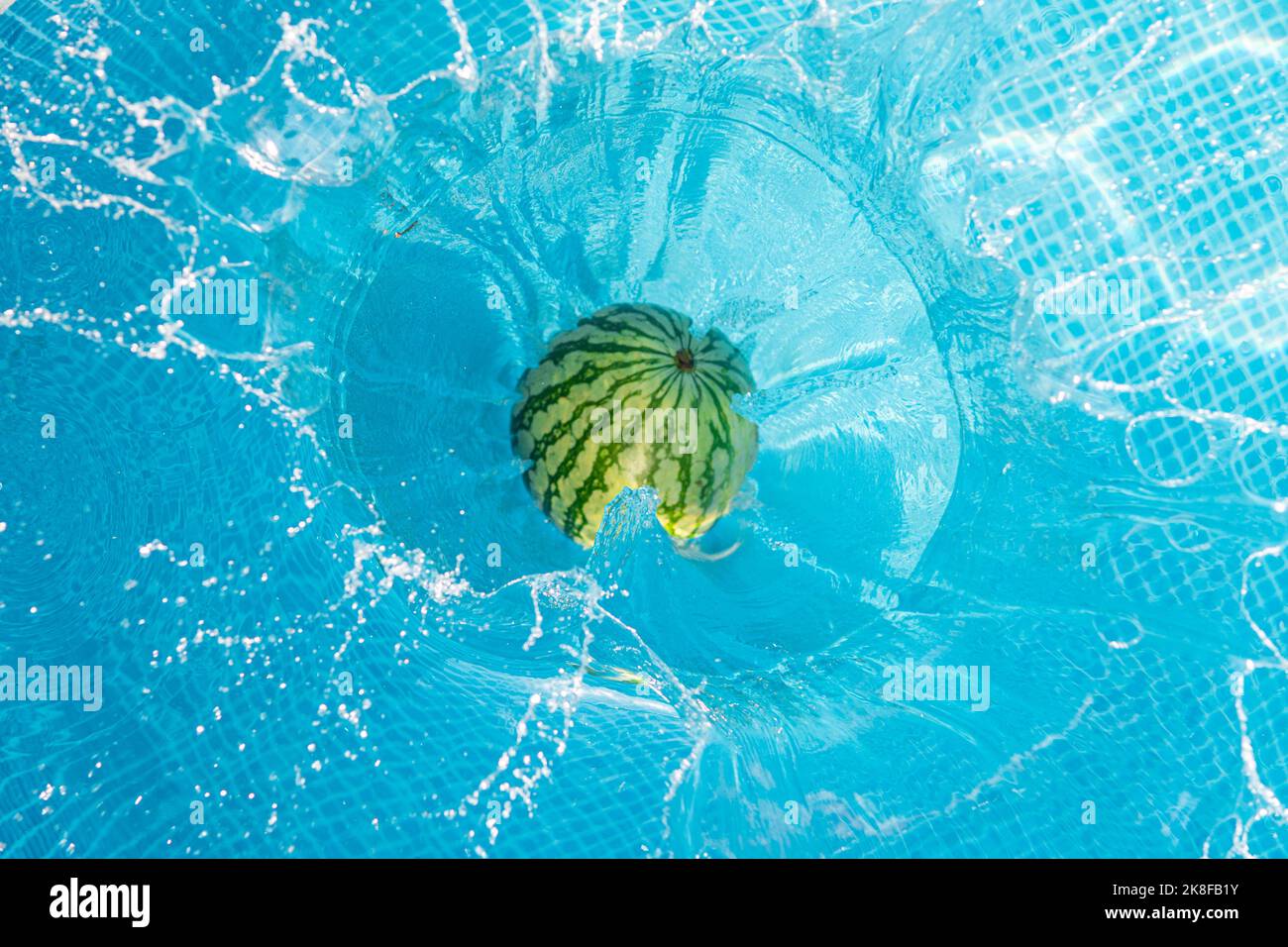 Cocomero che cade in piscina Foto Stock