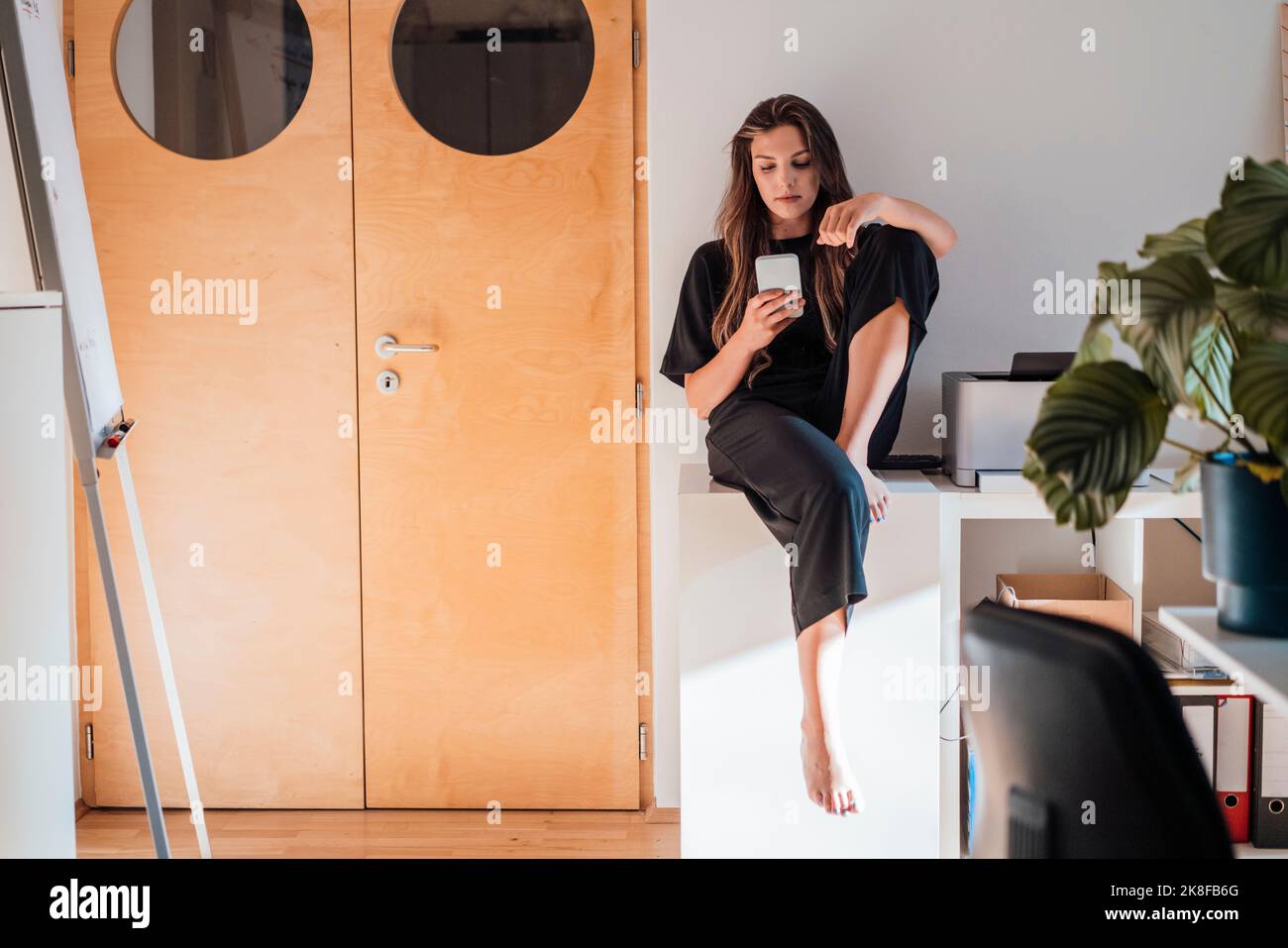 Messaggi di testo per le giovani donne tramite smartphone a casa Foto Stock