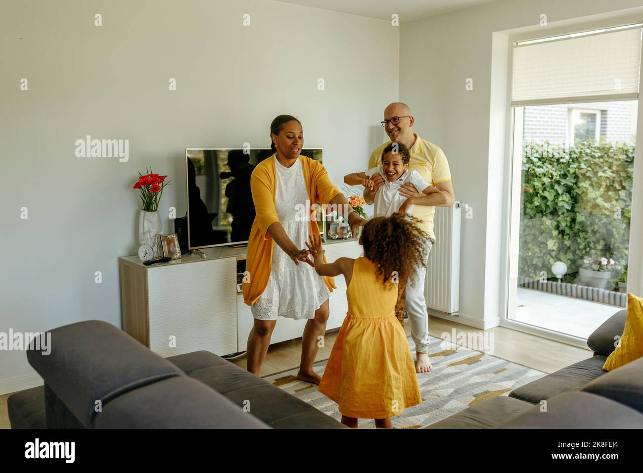 Felici i bambini con i genitori che ballano nel soggiorno di casa Foto Stock