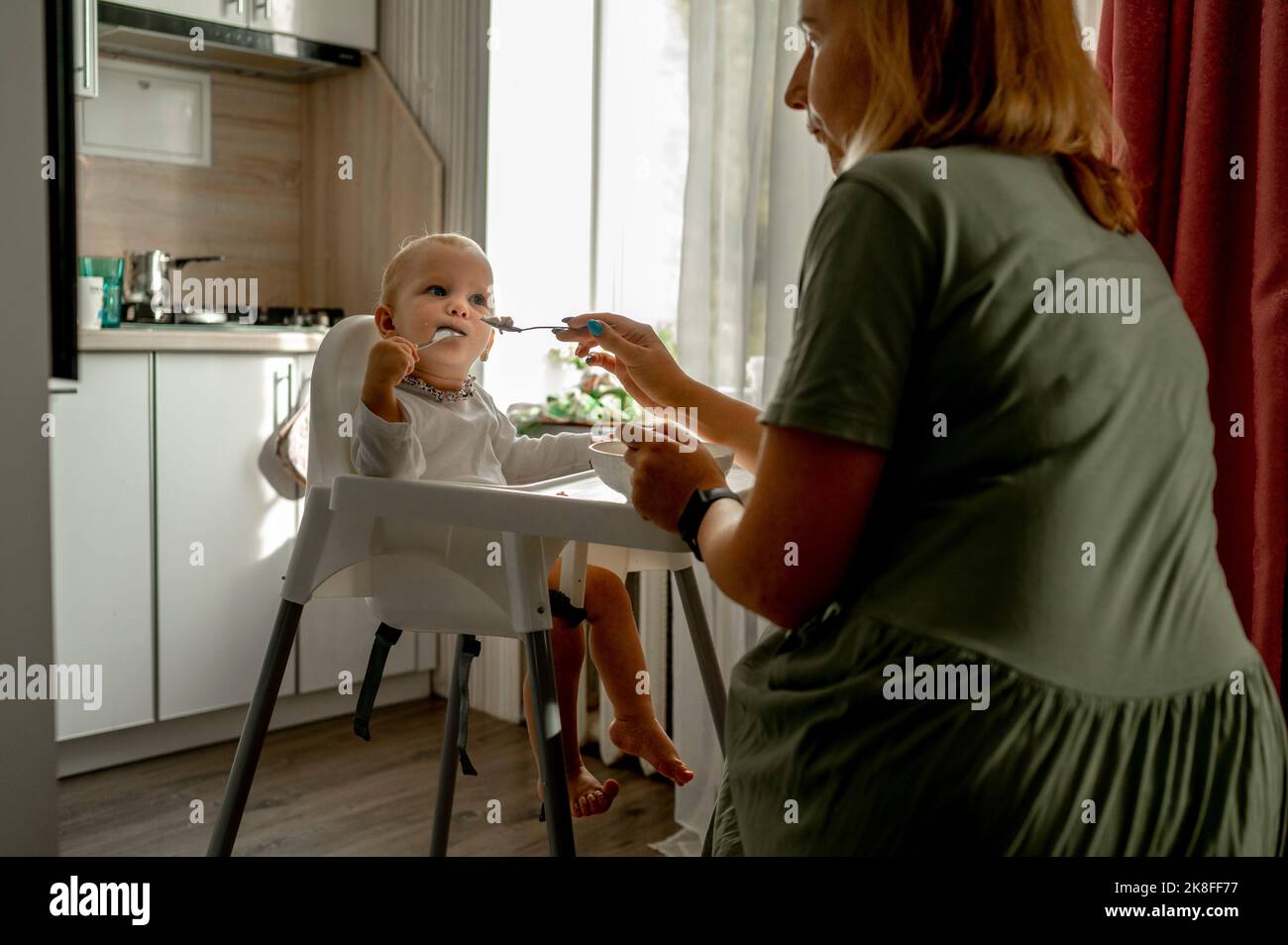 Madre figlia di alimentazione a casa Foto Stock