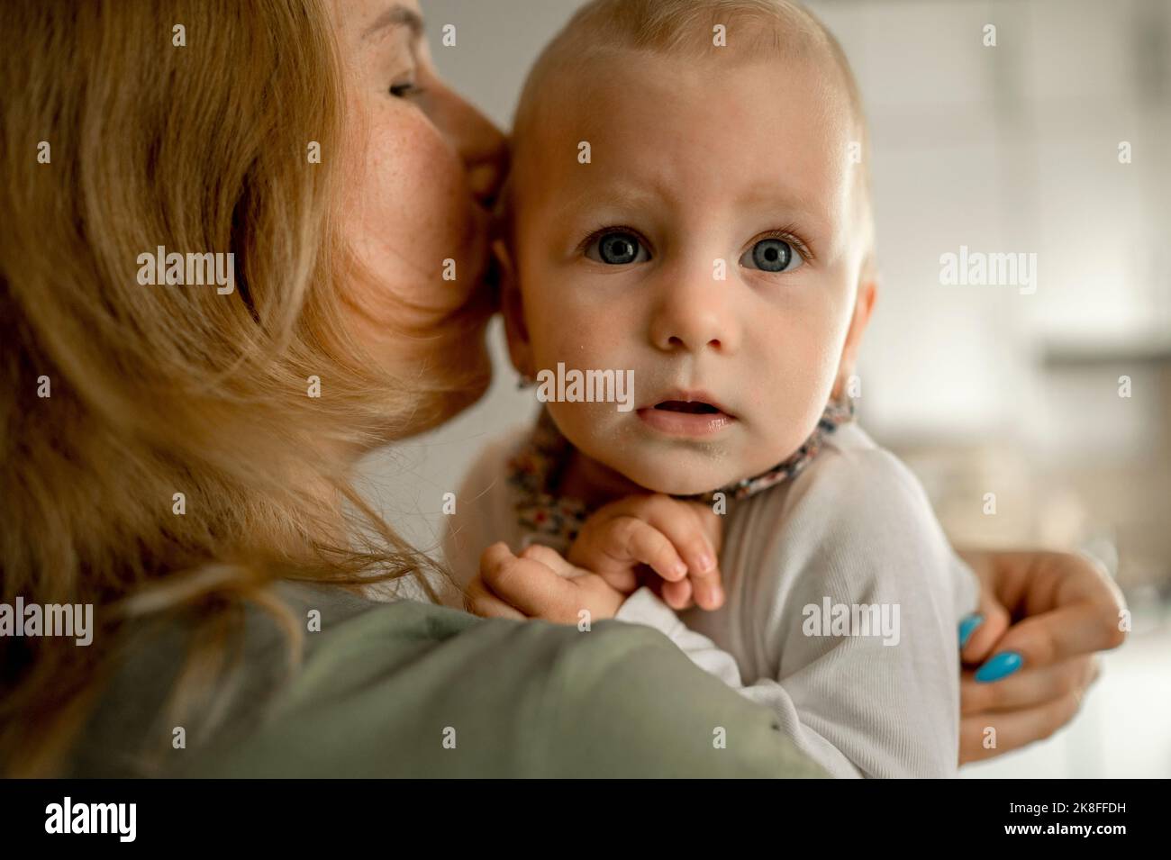 Madre che abbraccia la bambina a casa Foto Stock