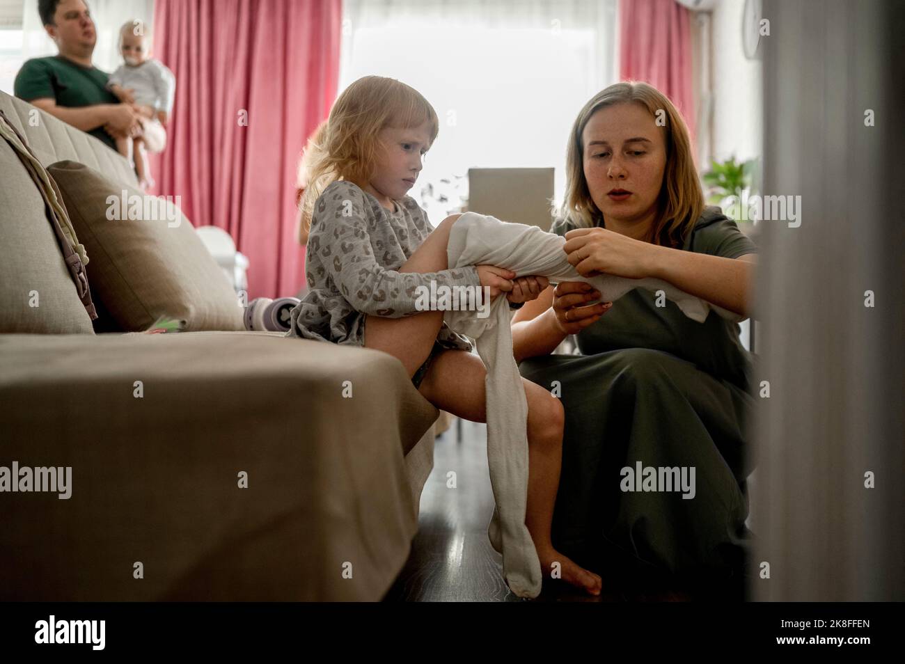 Madre aiutando figlia mettere su tights a casa Foto Stock