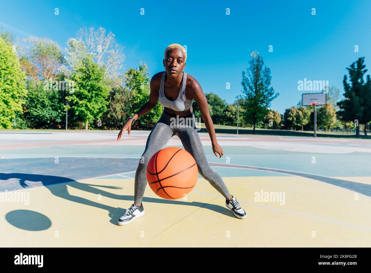 Giovane sportivo basket dribbling in campo sportivo Foto Stock