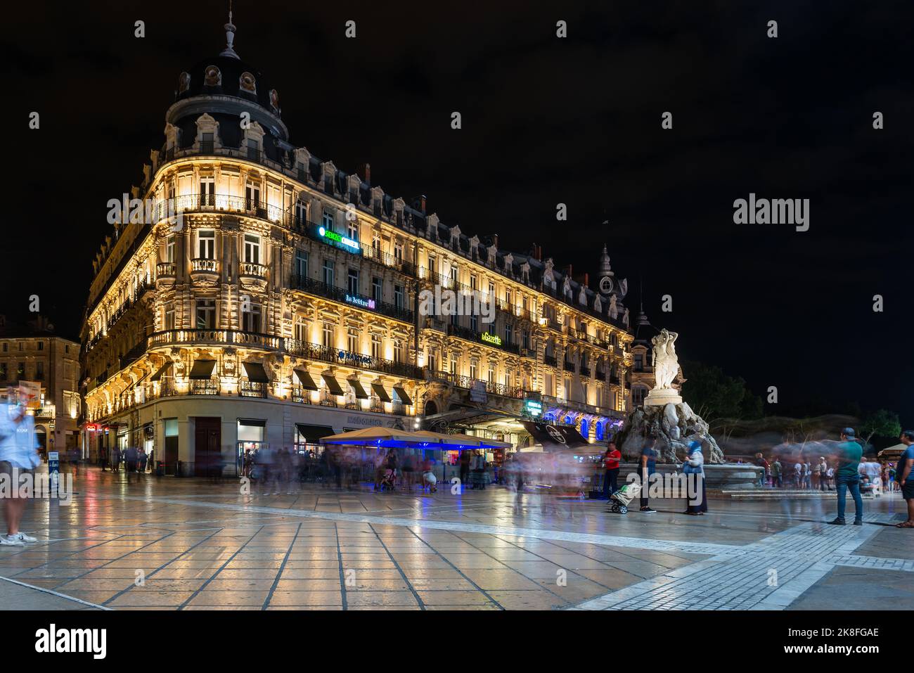 Comedy Square e le sue facciate classiche, e la Fontana delle tre grazie, di notte, a Montpellier, Occitanie, Francia Foto Stock