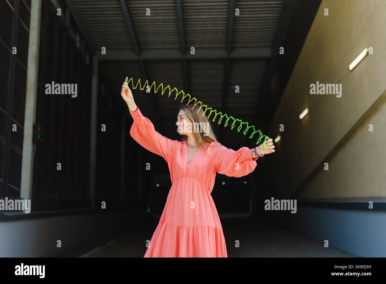 Donna felice stretching spiralato primavera giocattolo sul sentiero Foto Stock