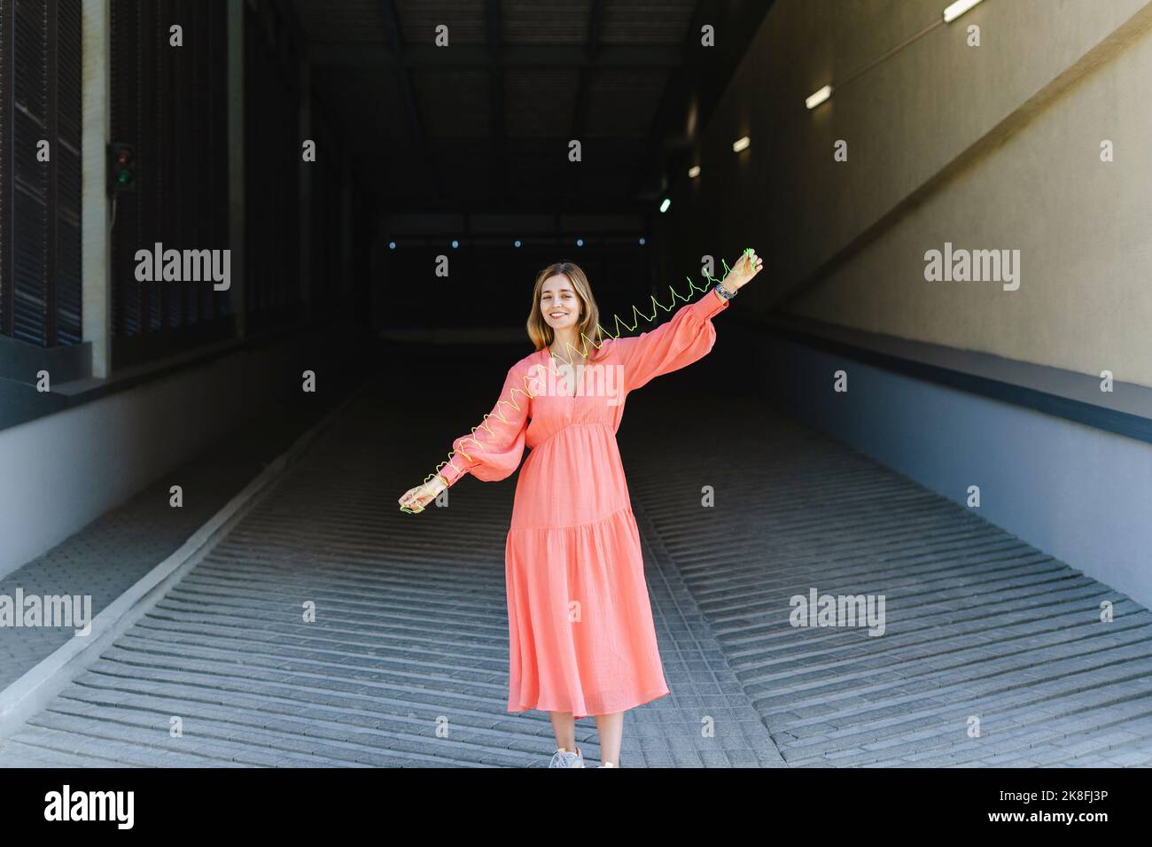 Donna sorridente stretching spiralato primavera giocattolo sul sentiero Foto Stock