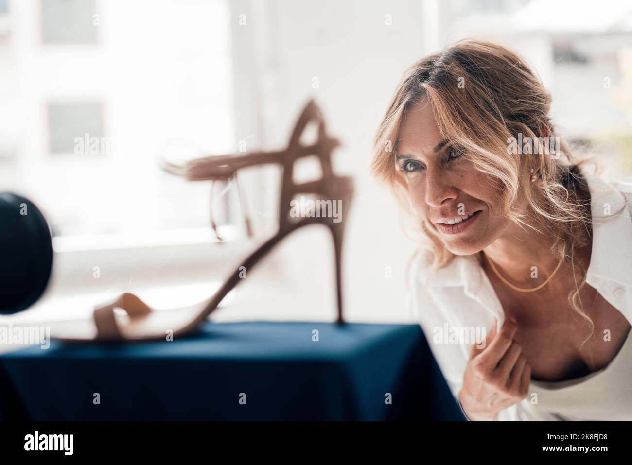 Donna matura che guarda il tallone alto Foto Stock